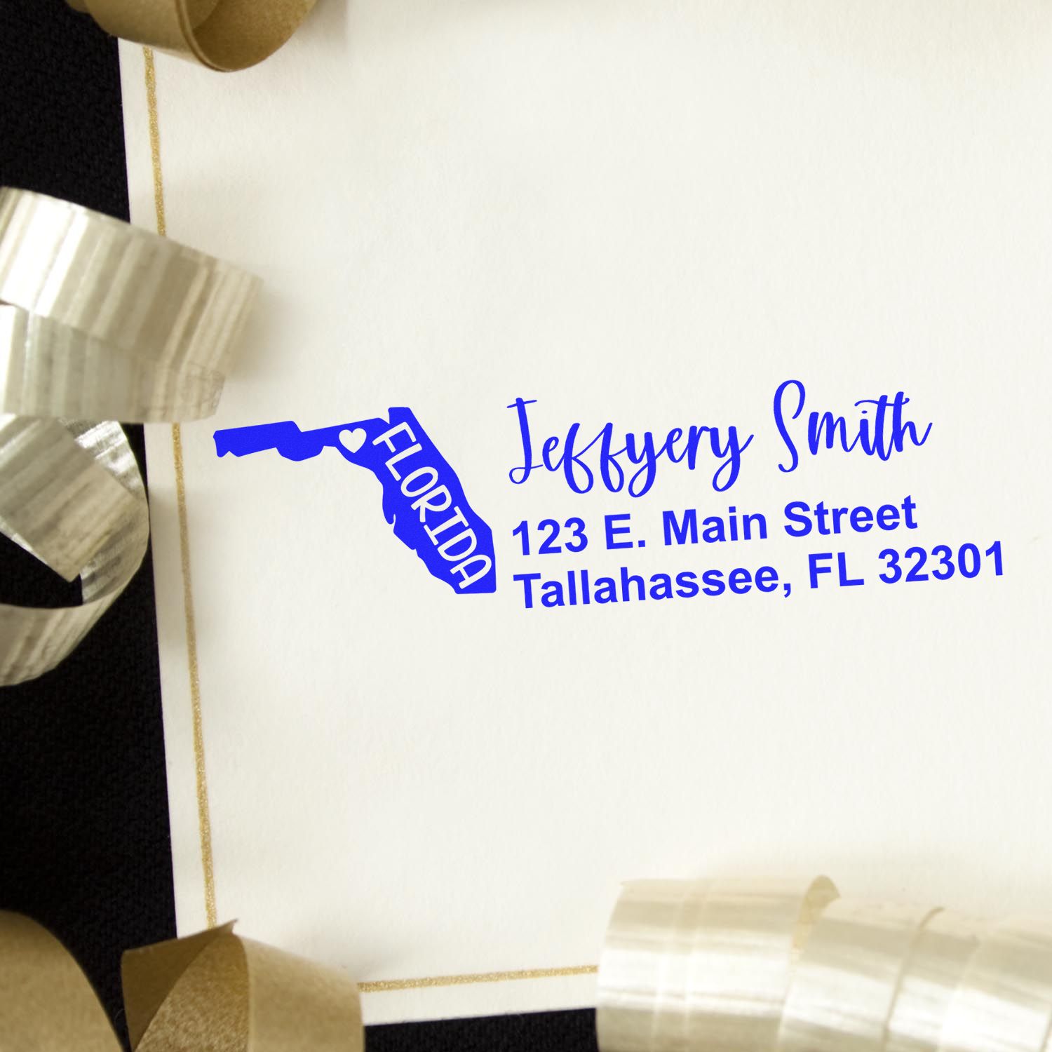 Florida State Love Personalized Address Stamp in blue ink on an envelope, featuring a Florida map design. The envelope is adorned with gold ribbon, showcasing a stylish and personalized touch.