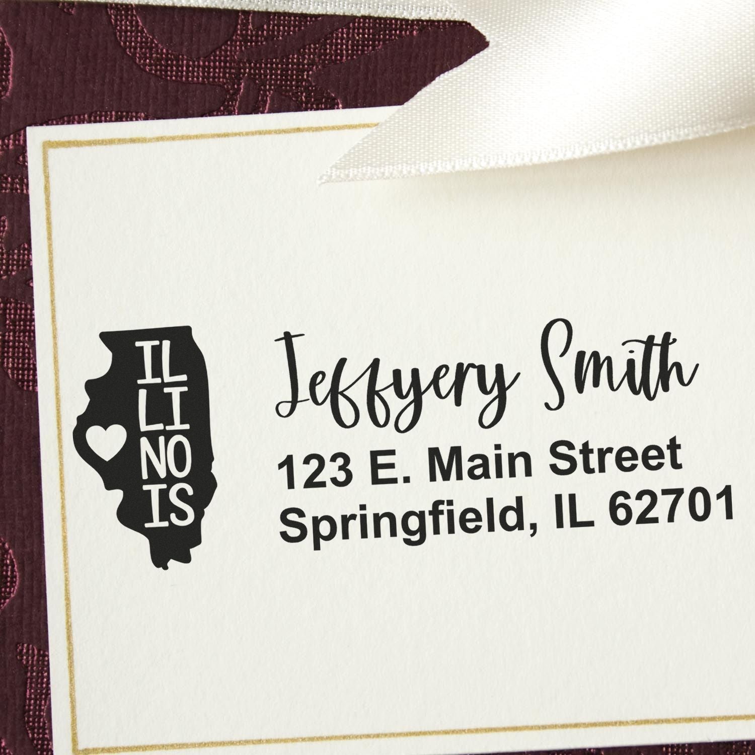 State Love of Illinois Custom Address Stamp Self-Inking on a card with 'Jeffery Smith, 123 E. Main Street, Springfield, IL 62701' in elegant font, featuring an Illinois state outline with a heart.