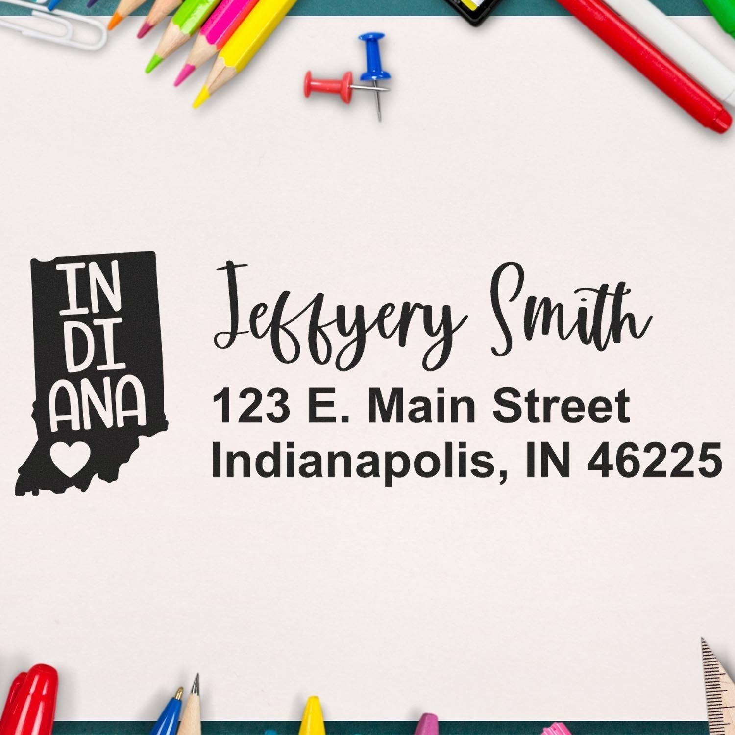 State Love of Indiana Custom Address Stamp Self-Inking on paper with colorful stationery around, featuring a heart design and personalized address for Jeffery Smith in Indianapolis.