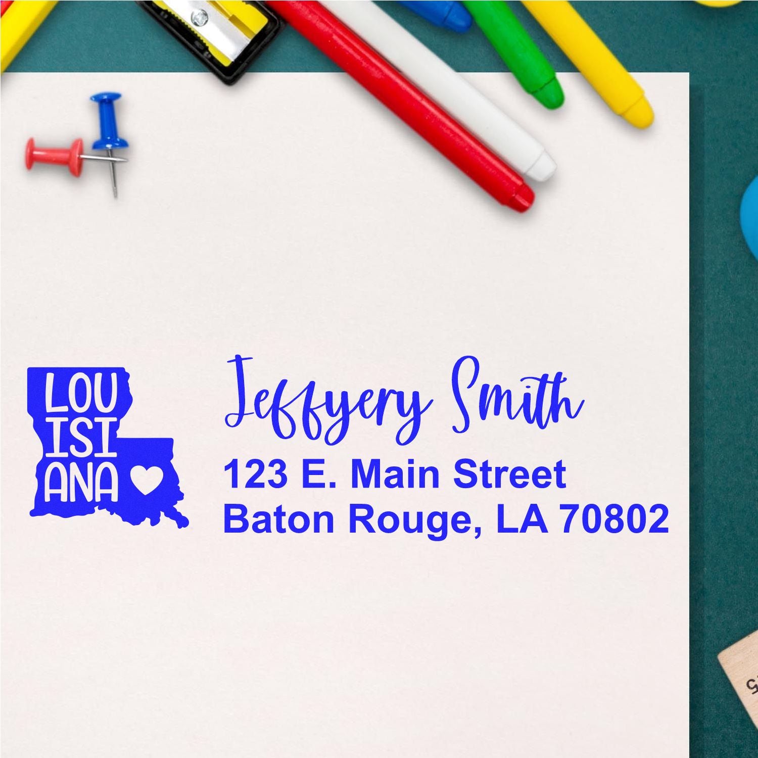 Louisiana State Love Personalized Address Stamp on white paper with colorful pens and push pins. Features a Louisiana state outline with a heart, personalized with name and address in blue ink.