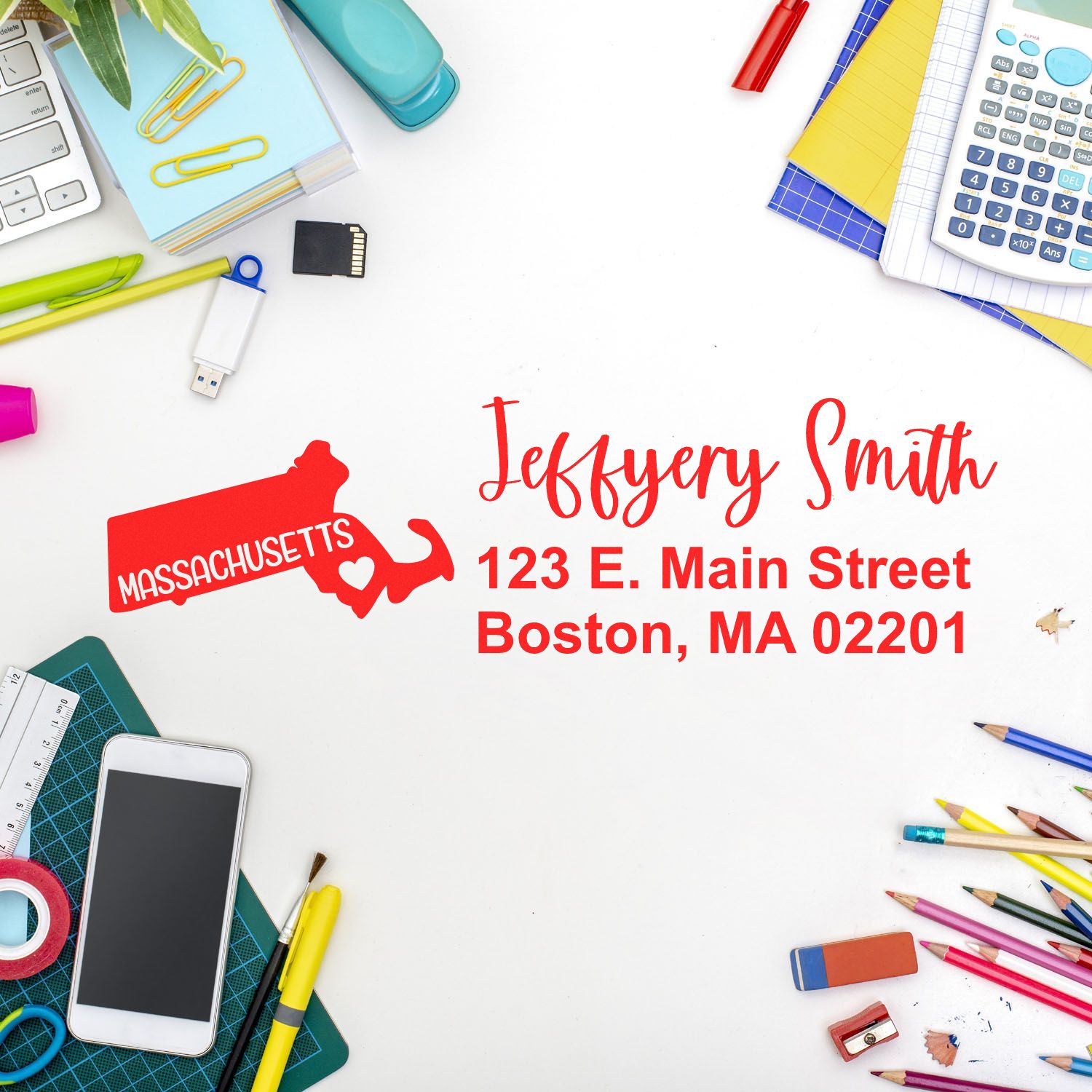 Desk with colorful stationery and a stamped envelope featuring the State Love of Massachusetts Custom Address Stamp Self-Inking, displaying a red Massachusetts outline and address in red ink.