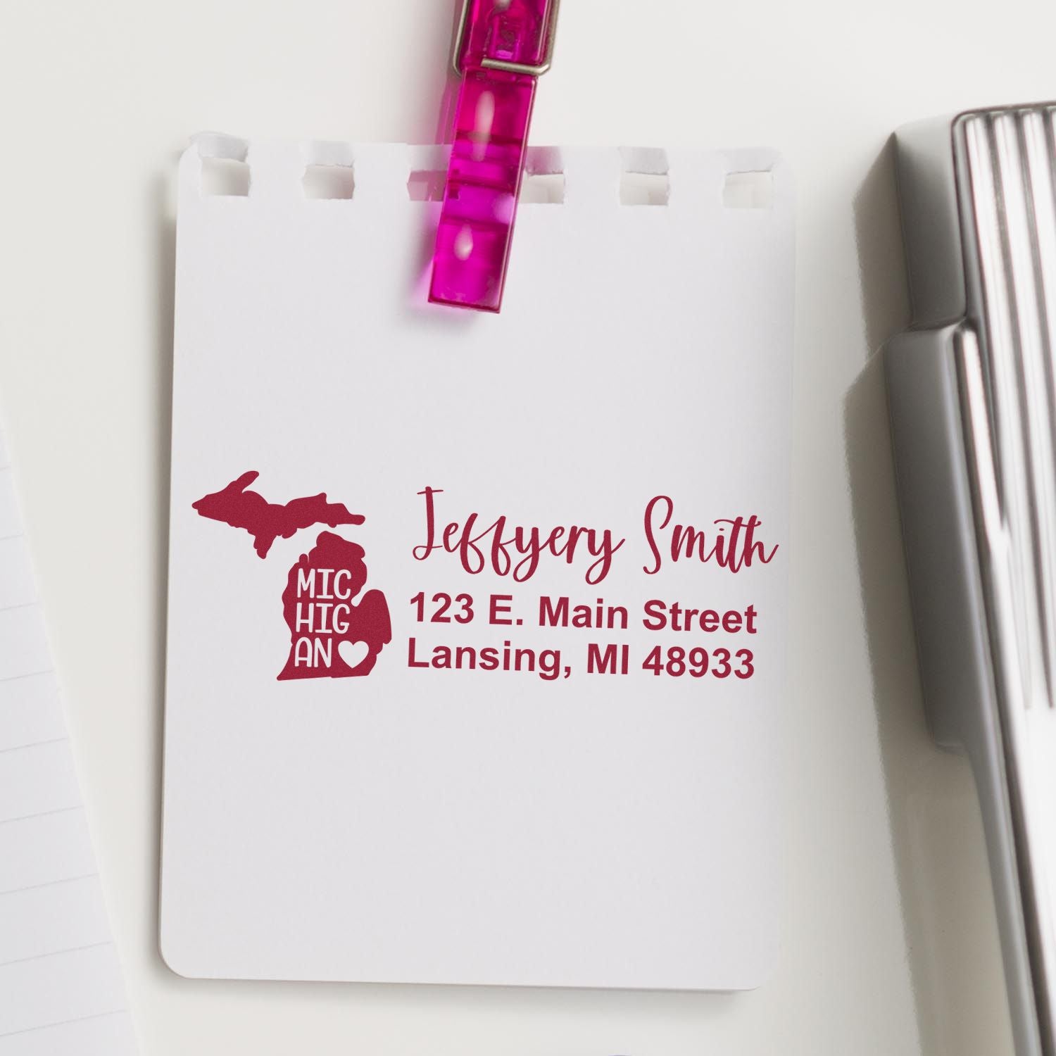 PSI Pre-Inked Michigan State Love Customized Address Stamp on white paper, featuring a red Michigan state outline with personalized address details, clipped with a pink clip.