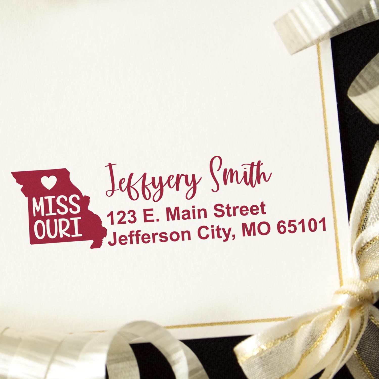 Missouri State Love Personalized Address Stamp on an envelope with a gold ribbon. Features a heart in the state outline and custom address in red. Perfect for adding a personal touch to mail.