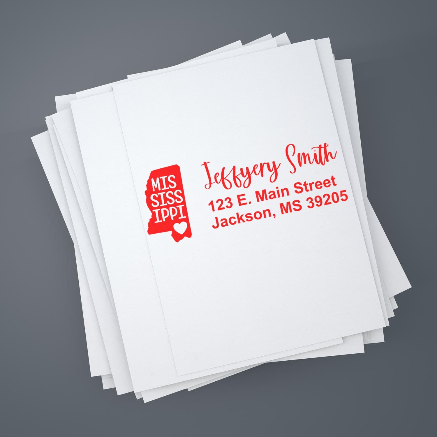 Stack of envelopes featuring the Mississippi State Love Personalized Address Stamp in red, displaying a name, address, and a heart within the state outline.