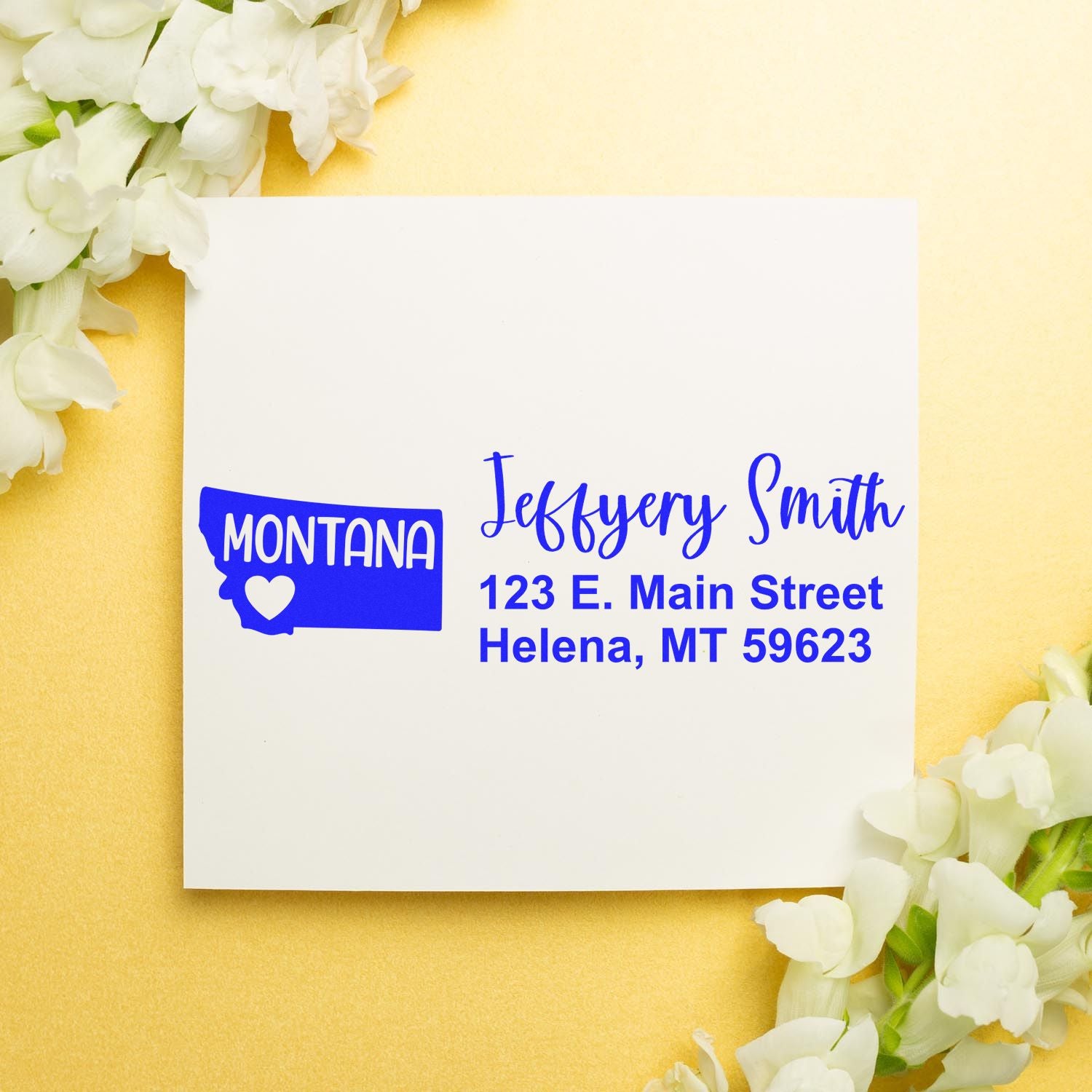 Montana State Love Personalized Address Stamp on a white card with blue text, featuring a Montana map and heart design. Surrounded by white flowers on a gold background.