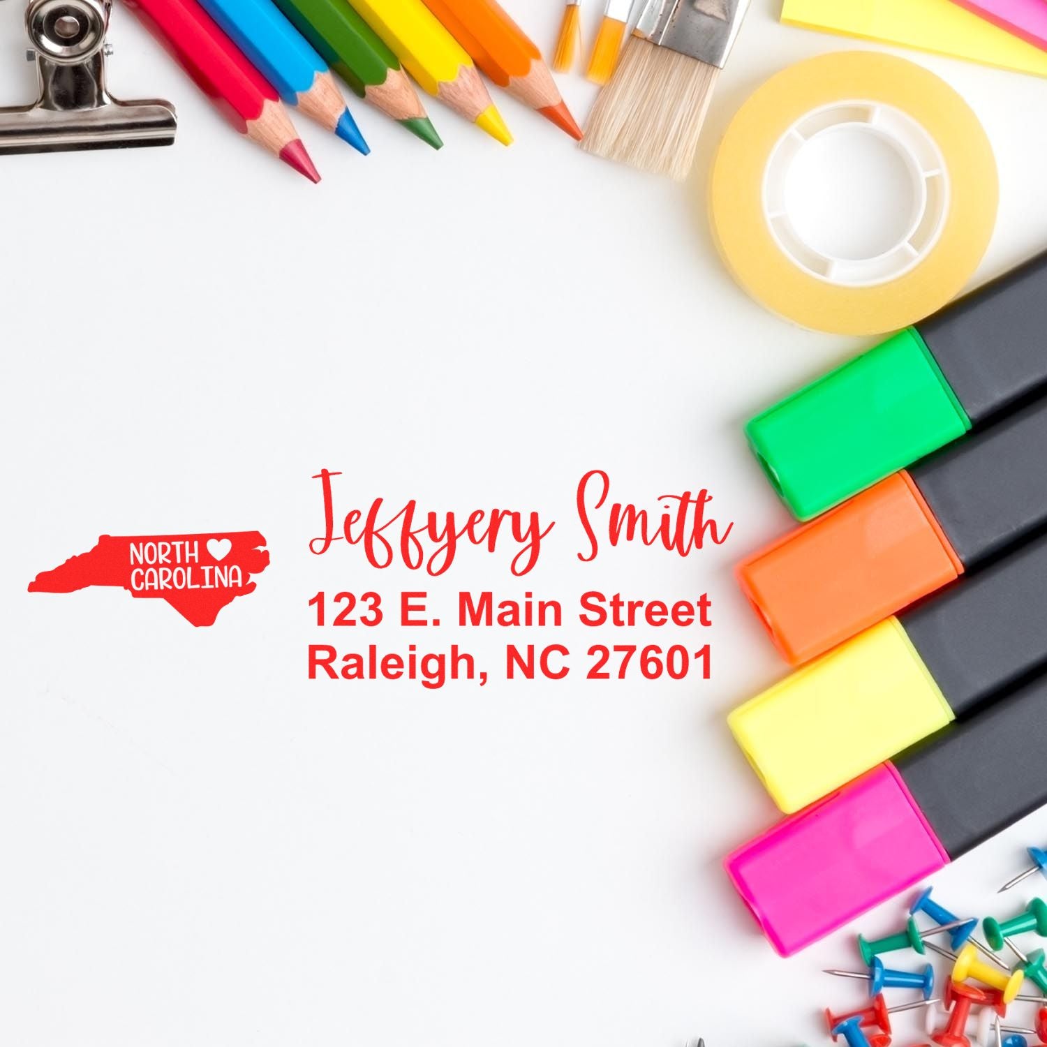 North Carolina State Love Personalized Address Stamp on white paper with colorful stationery, featuring a red state outline and sample address in red text.