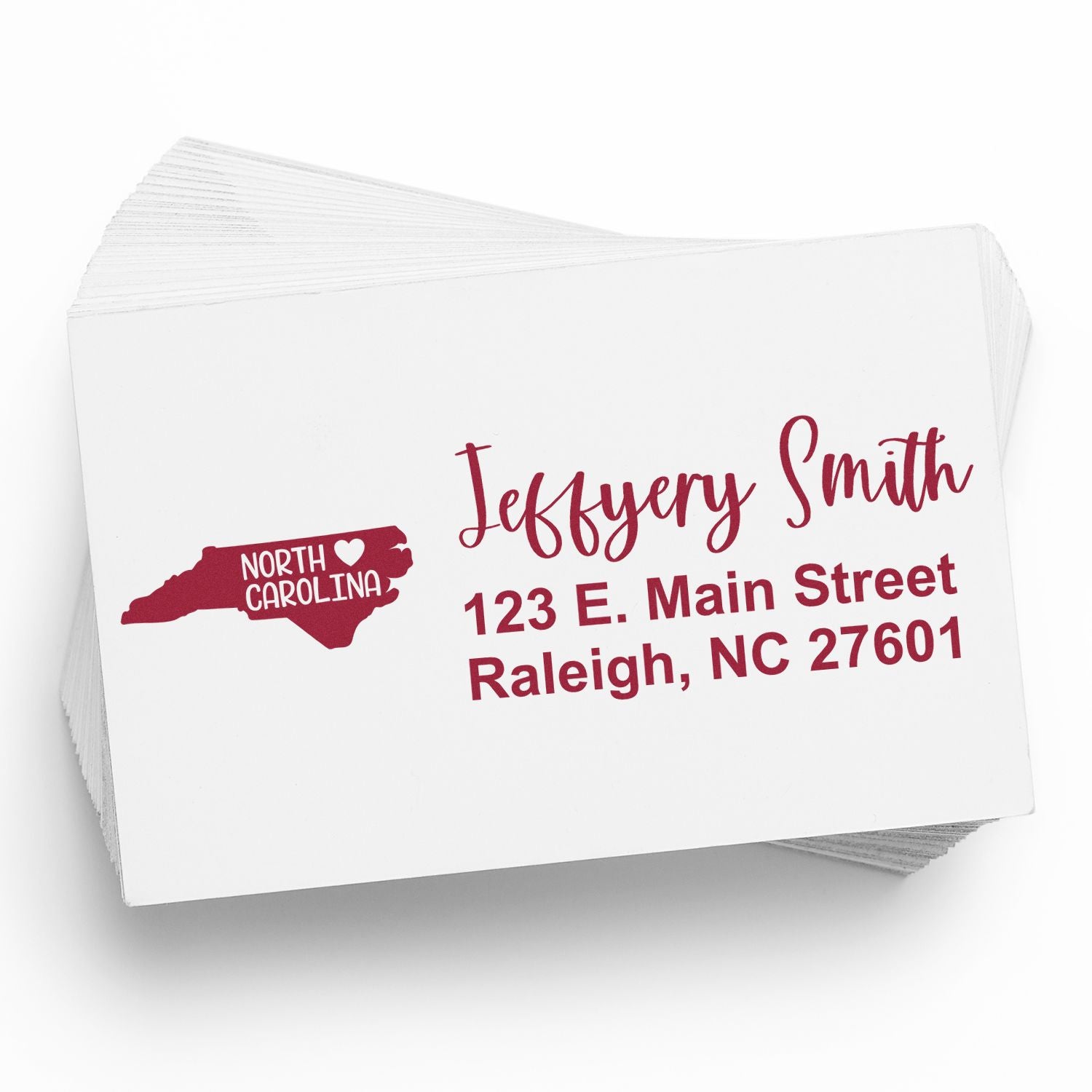 Image of a stack of envelopes featuring the North Carolina State Love Personalized Address Stamp with a red state outline and heart, alongside the name and address in elegant script.