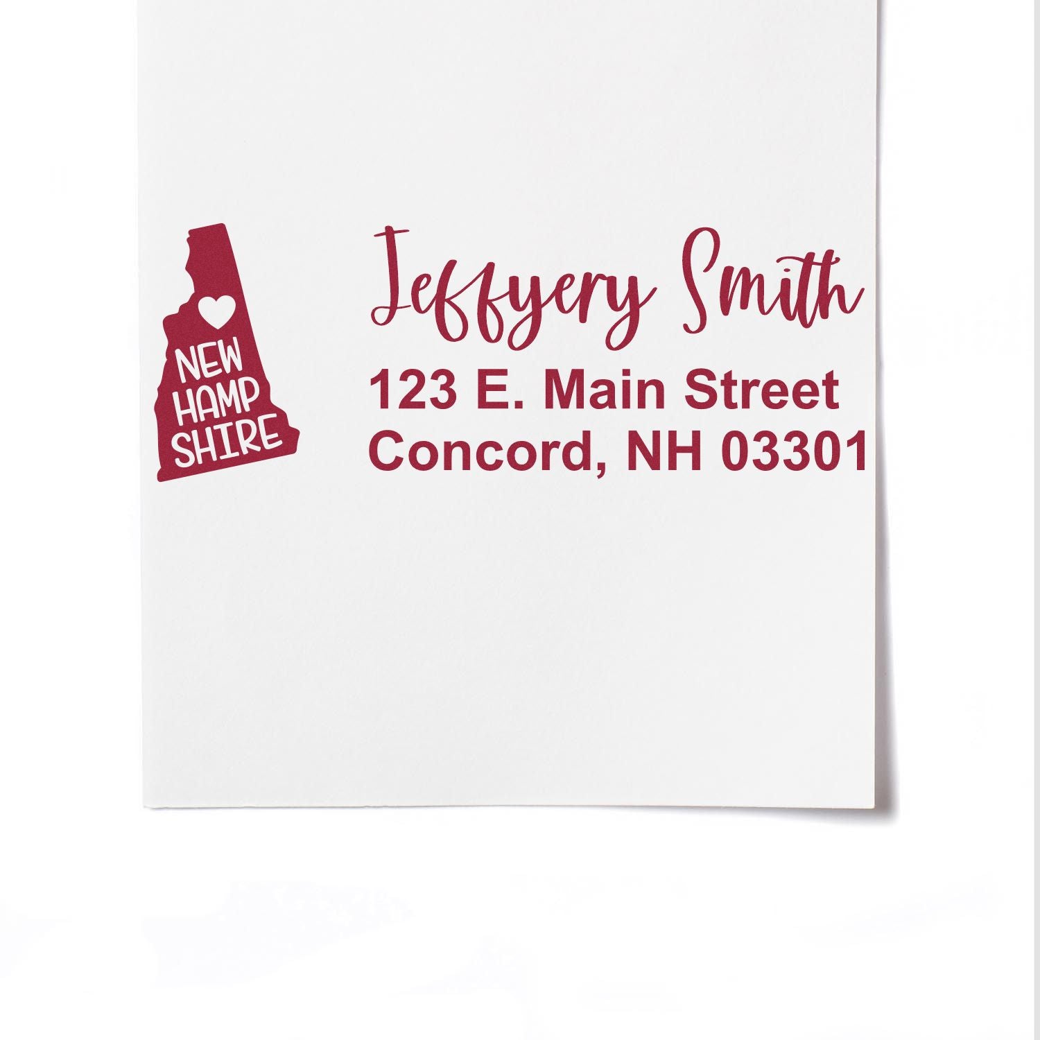 New Hampshire State Love Personalized Address Stamp on white paper, featuring a red state silhouette with a heart and address text in elegant font. Perfect for adding a personal touch to mail.