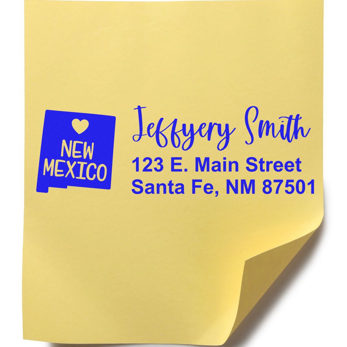 Yellow sticky note with blue text showing the New Mexico State Love Personalized Address Stamp design, featuring a heart and state outline, with sample address: 123 E. Main Street, Santa Fe, NM 87501.