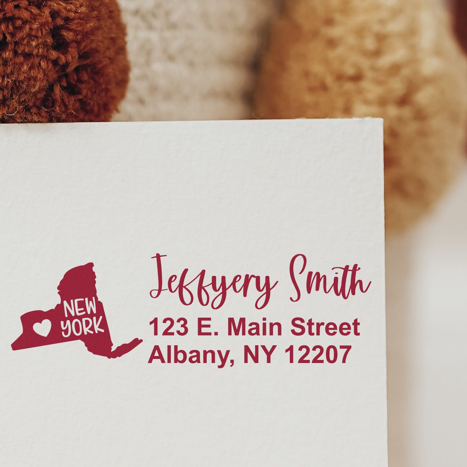 New York State Love Personalized Address Stamp on an envelope, featuring a red state outline with a heart and New York text, alongside a sample address in elegant script.