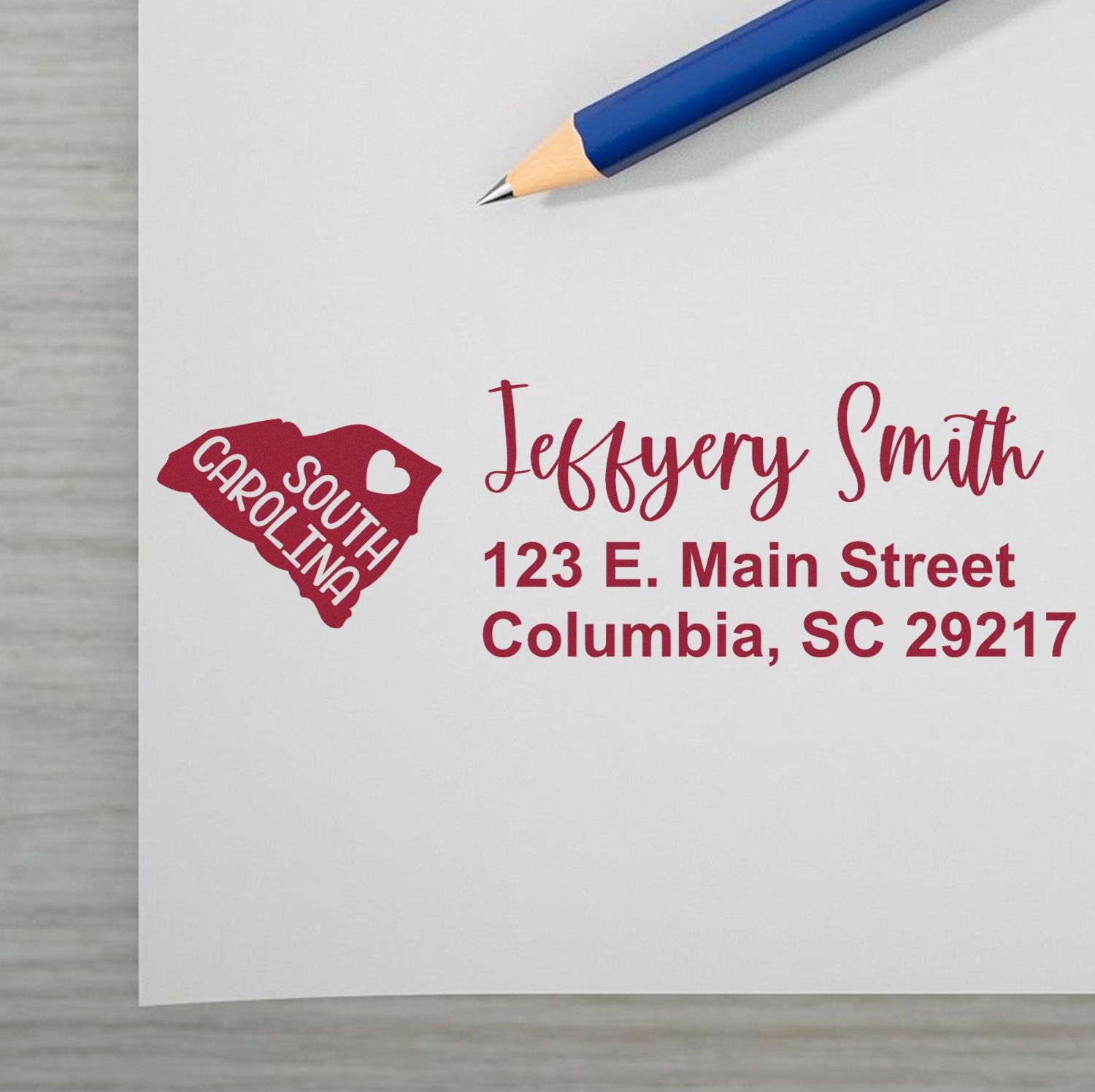 Image of a letter with the State Love of South Carolina Custom Address Stamp Self-Inking featuring a red South Carolina state outline and address details in red ink next to a blue pencil.