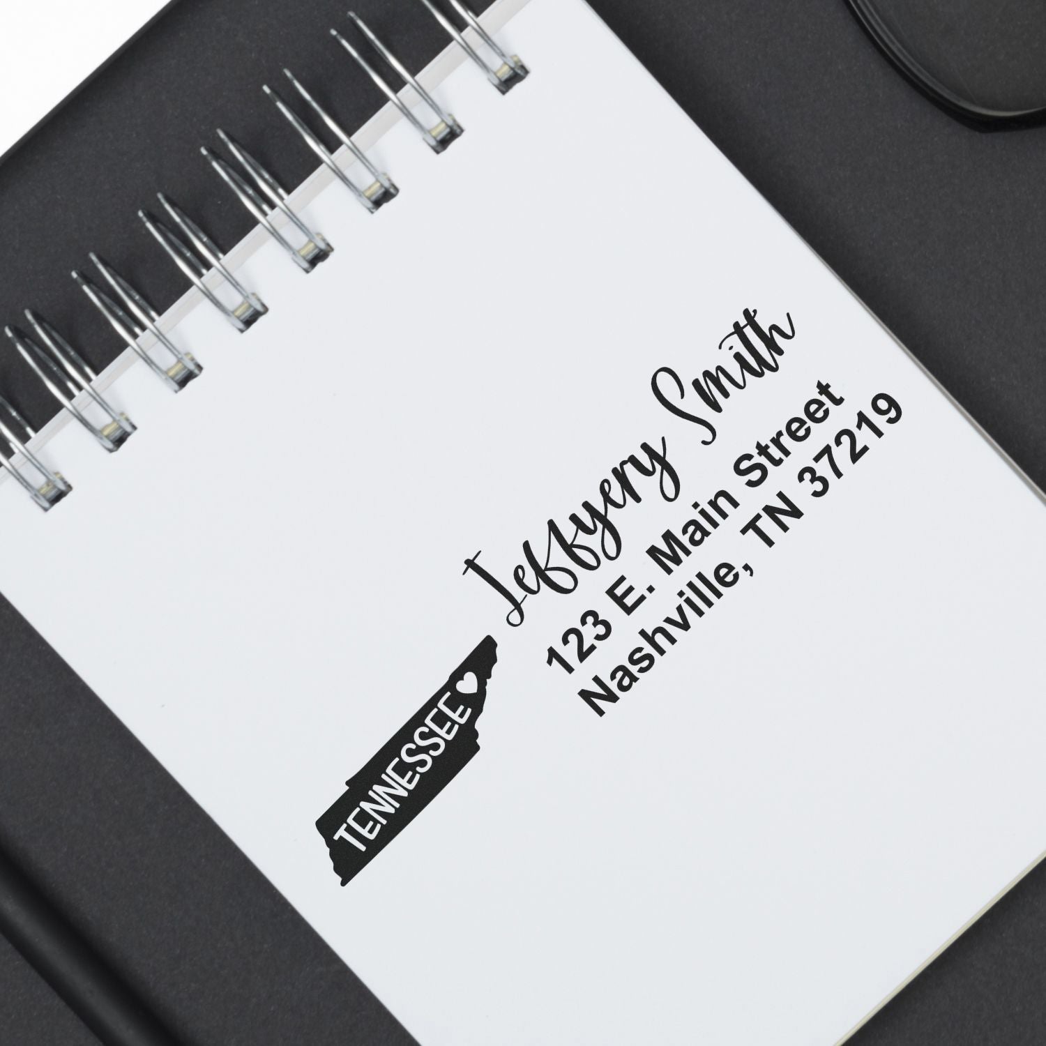 PSI Pre-Inked Tennessee State Love Customized Address Stamp on a notebook, displaying Tennessee with a heart and an address in elegant script. Perfect for personalizing mail with style.