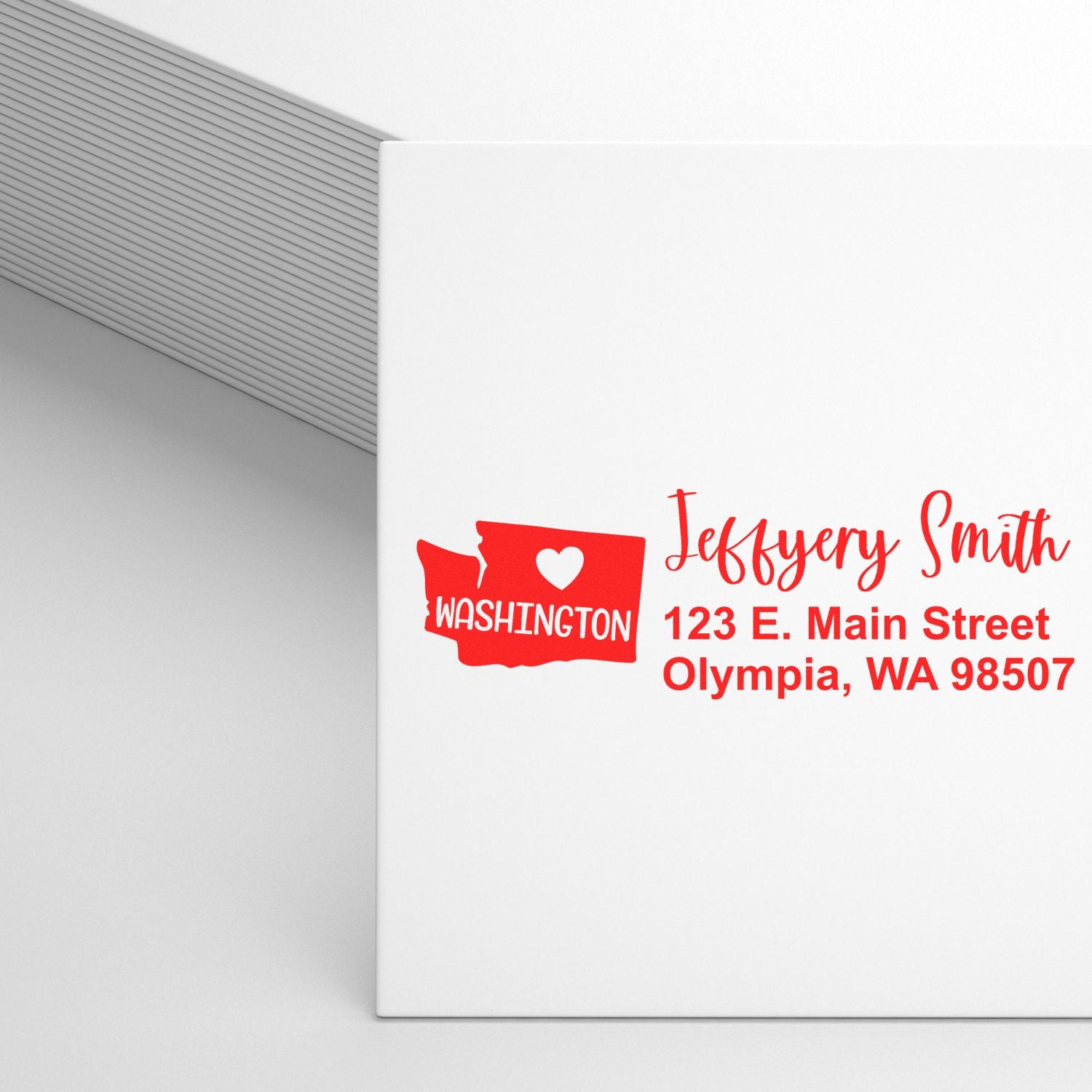 State Love of Washington Custom Address Stamp Self-Inking displayed on a white envelope, featuring a red Washington state outline with a heart and personalized address in red text.