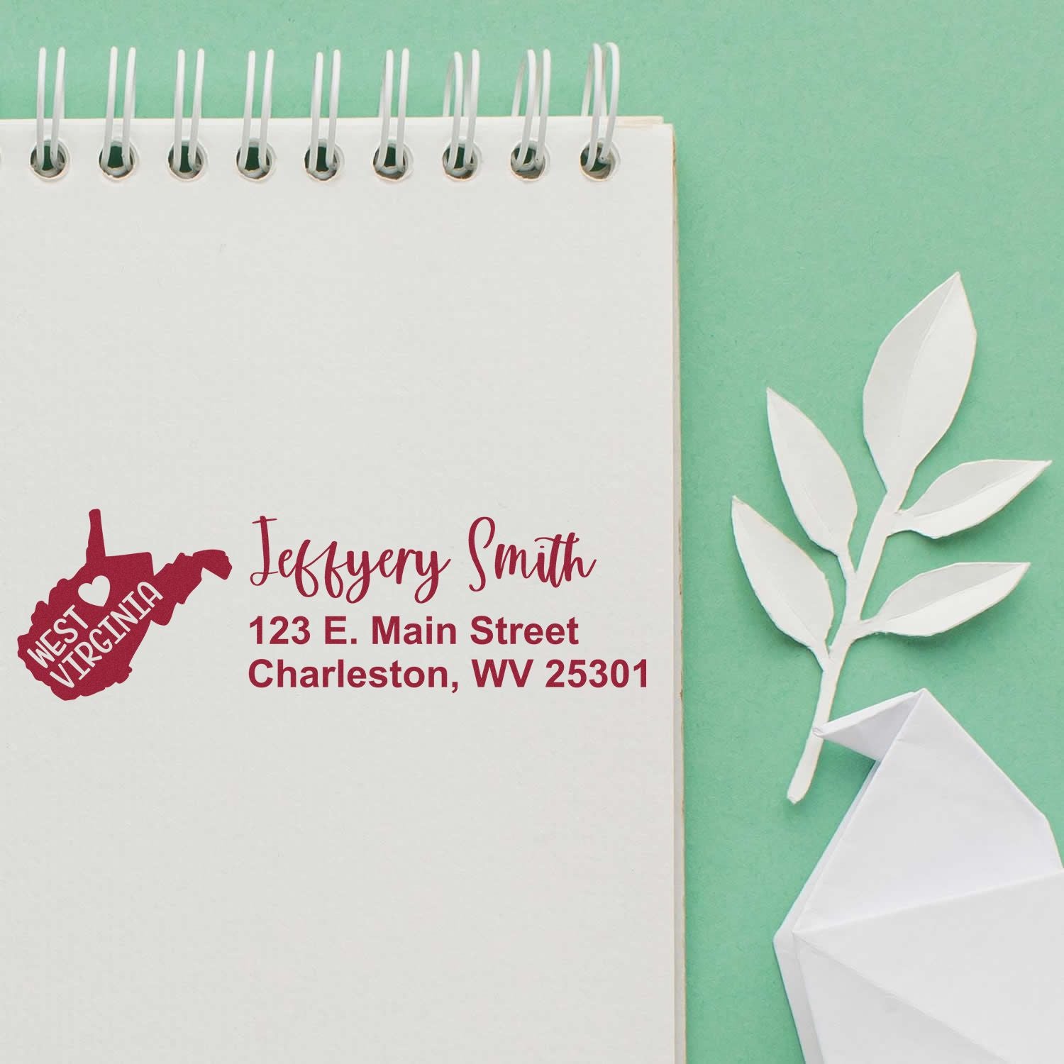 PSI Pre-Inked West Virginia State Love Customized Address Stamp on notepad with green background, featuring a red state outline and personalized address for Jeffery Smith in Charleston, WV.