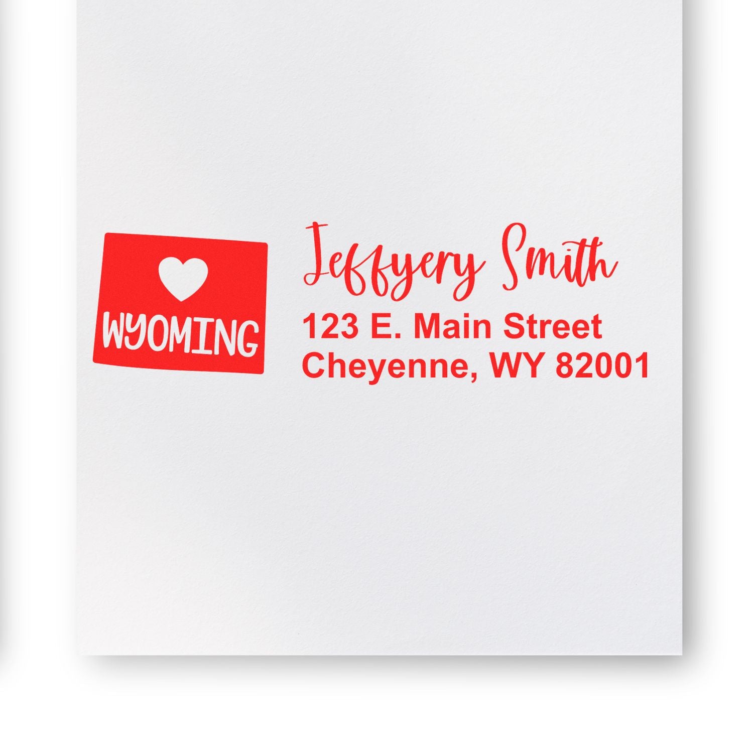 Slim Wyoming Custom Address Stamp for Envelopes displayed on white paper, featuring a red heart design with Wyoming and personalized address in red text.