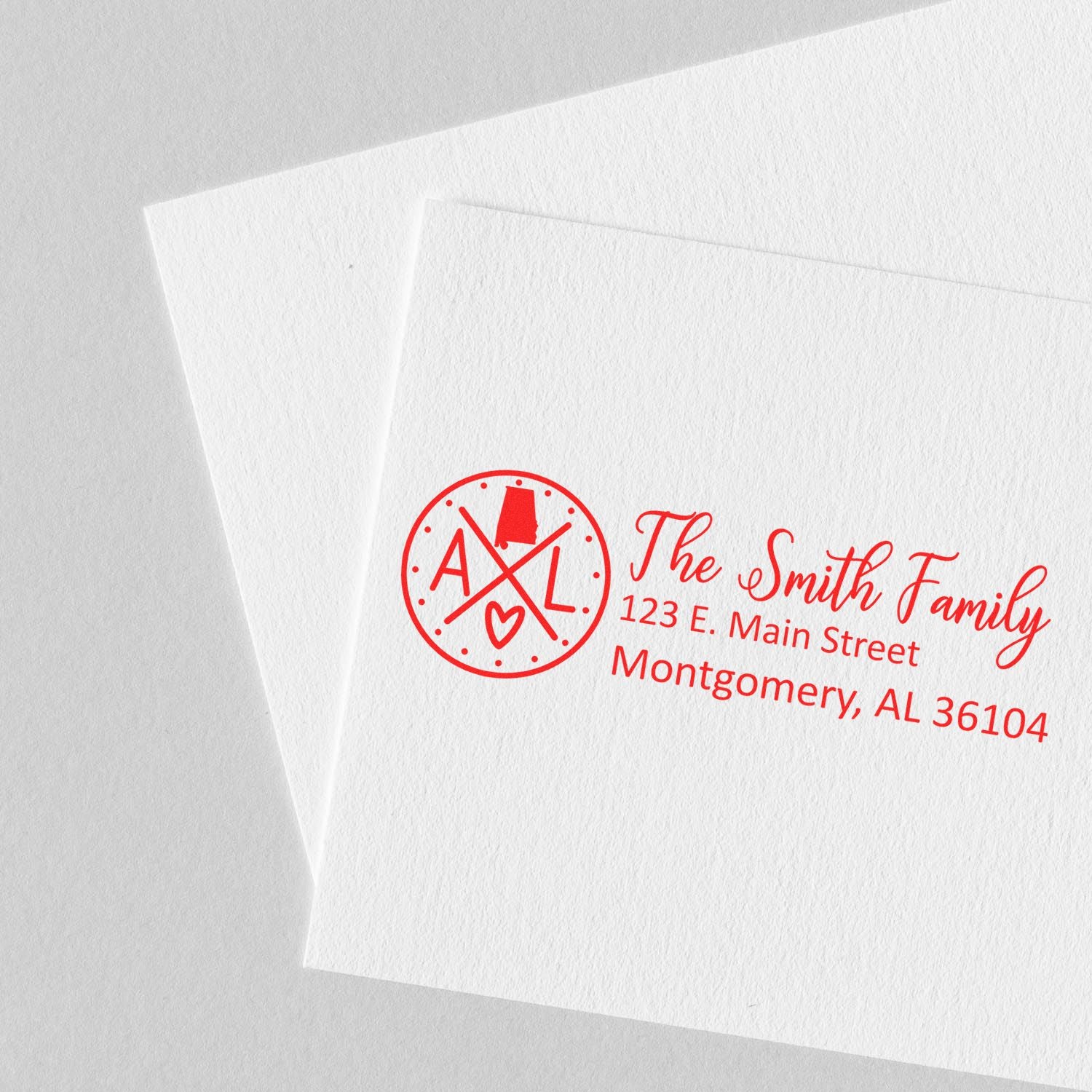 Alabama State Pride Customized Address Stamp in red ink on white paper, featuring a circular design with AL and a heart, alongside personalized address details for the Smith Family in Montgomery.