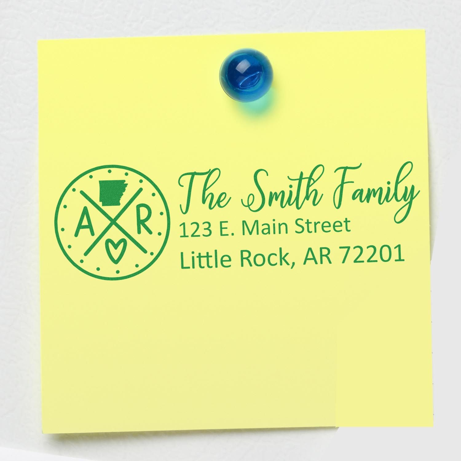 Arkansas State Pride Customized Address Stamp on a yellow note with The Smith Family, 123 E. Main Street, Little Rock, AR 72201 in green text, pinned with a blue magnet.