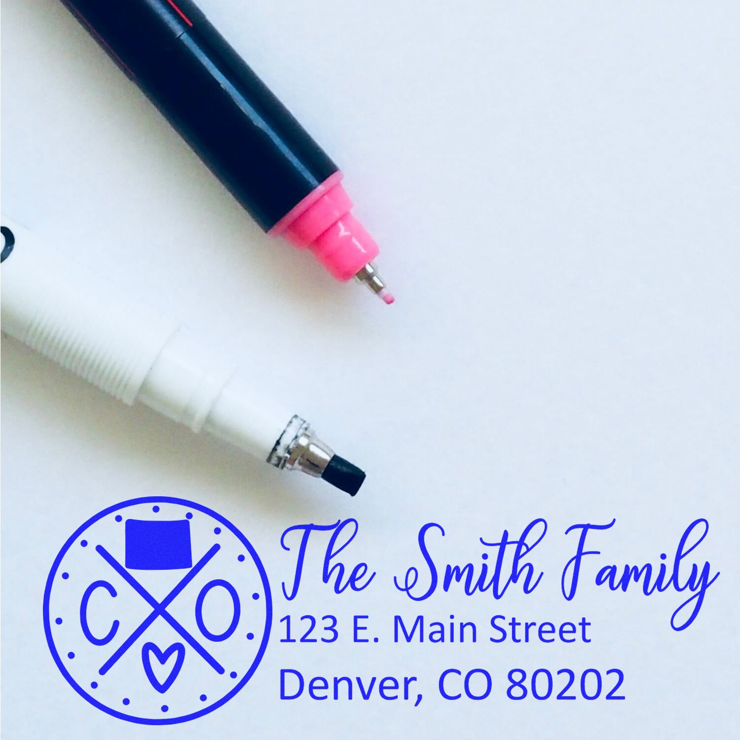 Colorado State Pride Customized Address Stamp featuring a circular design with 'CO' and a heart, shown with two pens. Personalized with 'The Smith Family, 123 E. Main Street, Denver, CO 80202.'