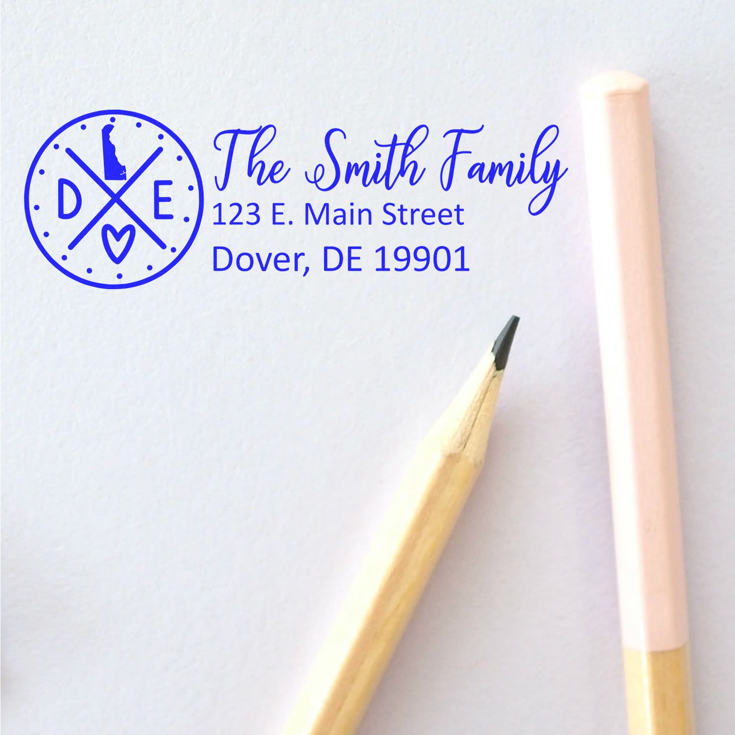 Self-Inking State Love of Delaware Custom Address Stamp on white paper with a pencil and pink eraser. Features The Smith Family and a Delaware state outline.