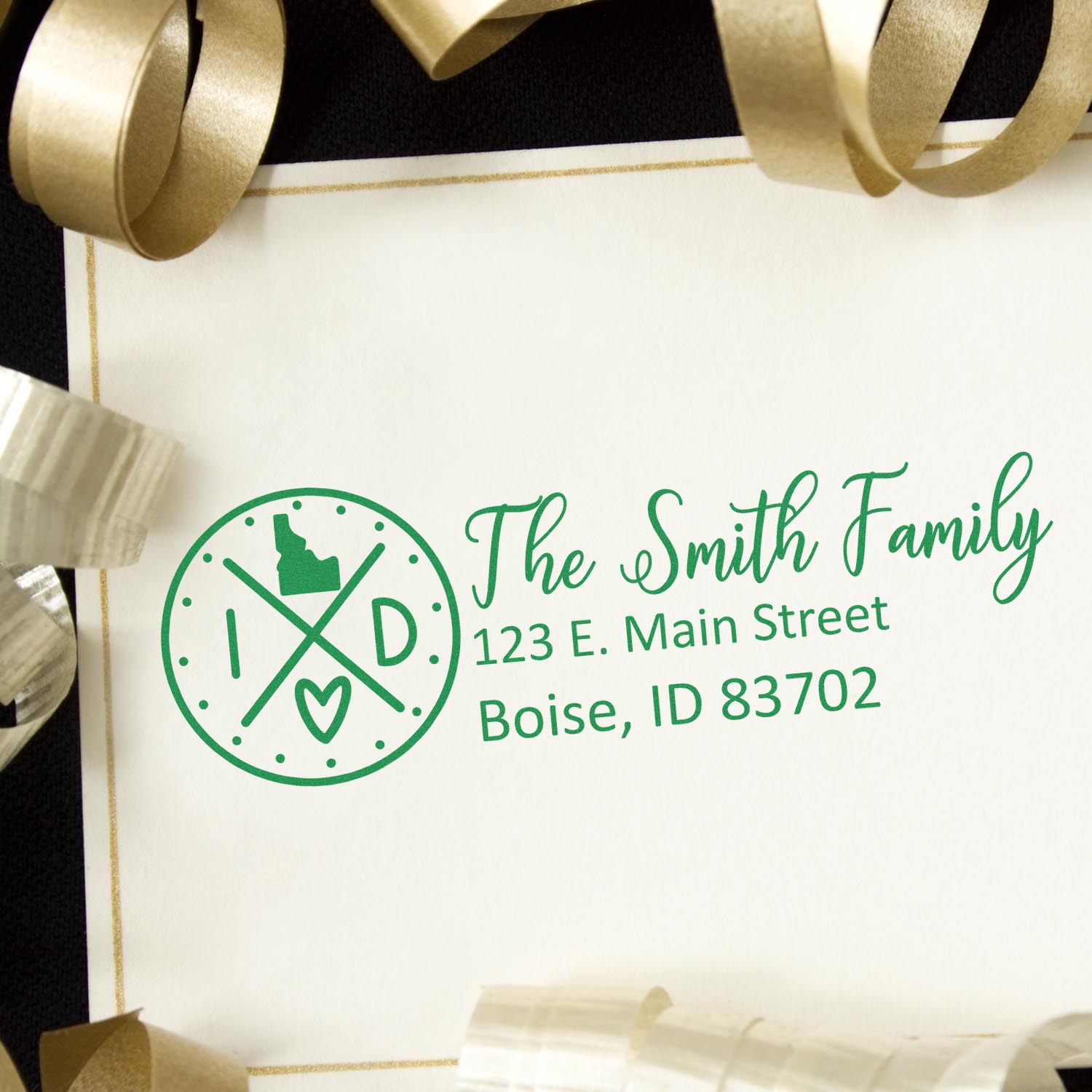 PSI Pre-Inked Idaho State Pride Customized Address Stamp on an envelope with gold ribbon, featuring a green design with the Idaho state outline and personalized address for the Smith Family in Boise.