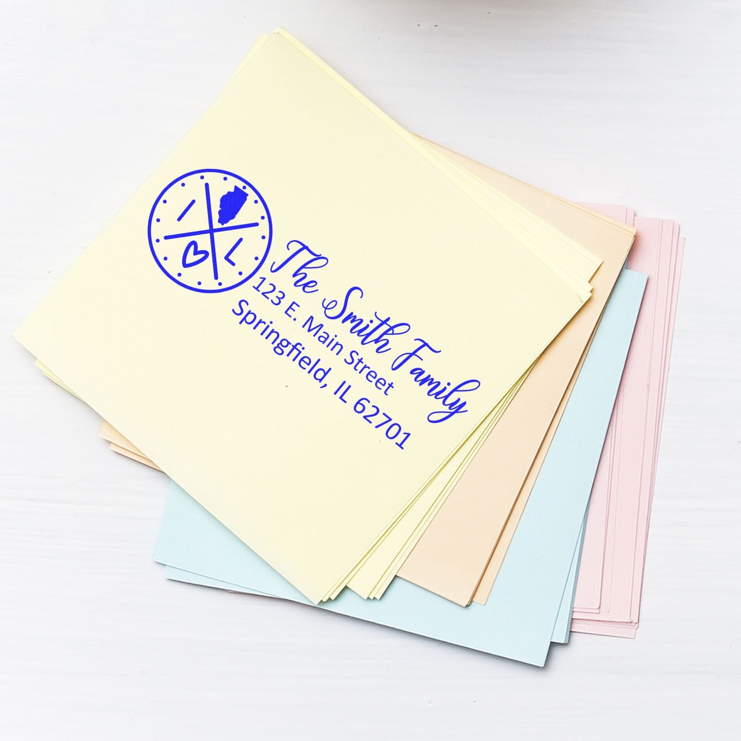 Stack of pastel envelopes featuring the Illinois State Pride Customized Address Stamp with a heart and state outline design, personalized with The Smith Family and Springfield, IL address.