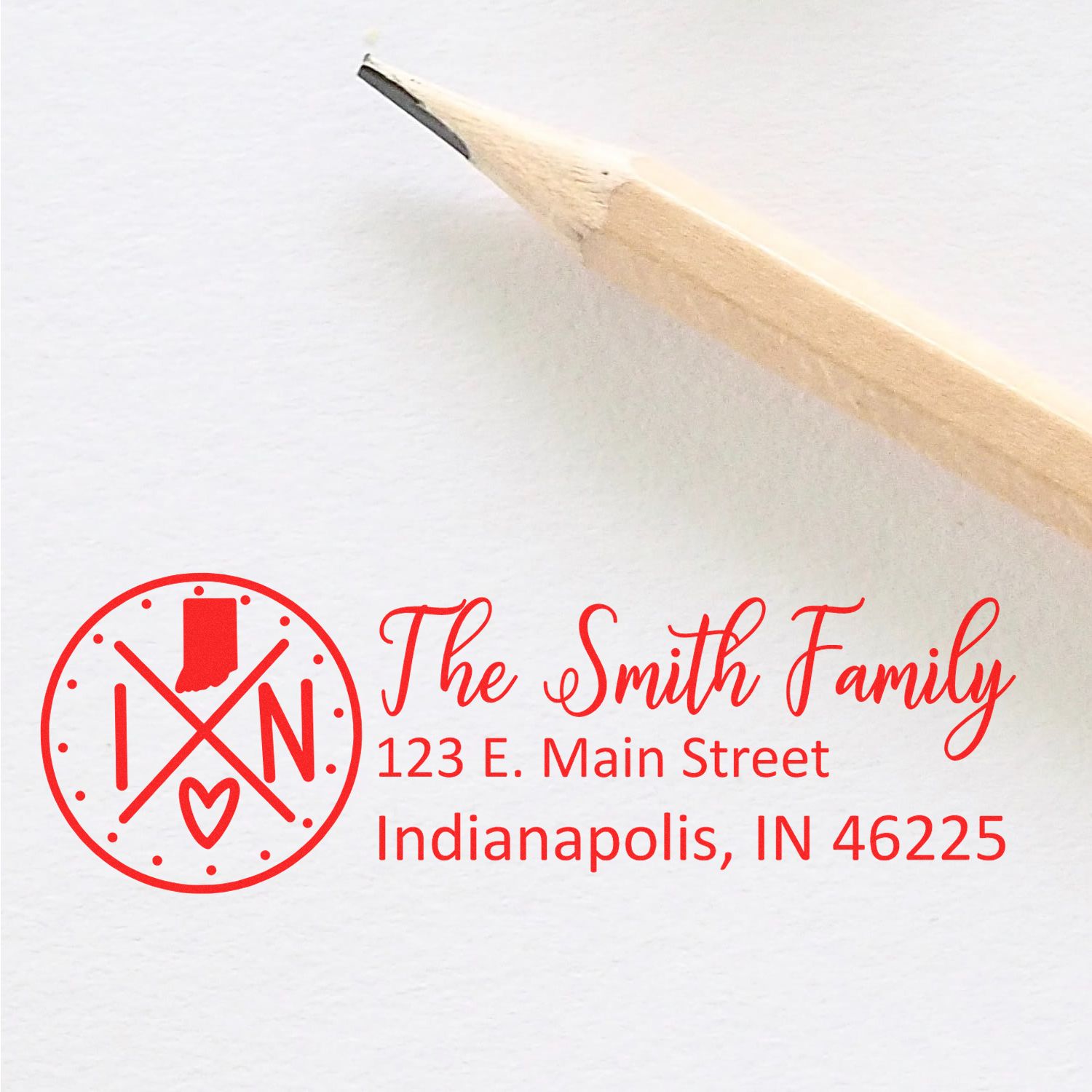 Self-Inking State Love of Indiana Custom Address Stamp in red ink on white paper, featuring a circular Indiana state design with a heart, next to a wooden pencil.