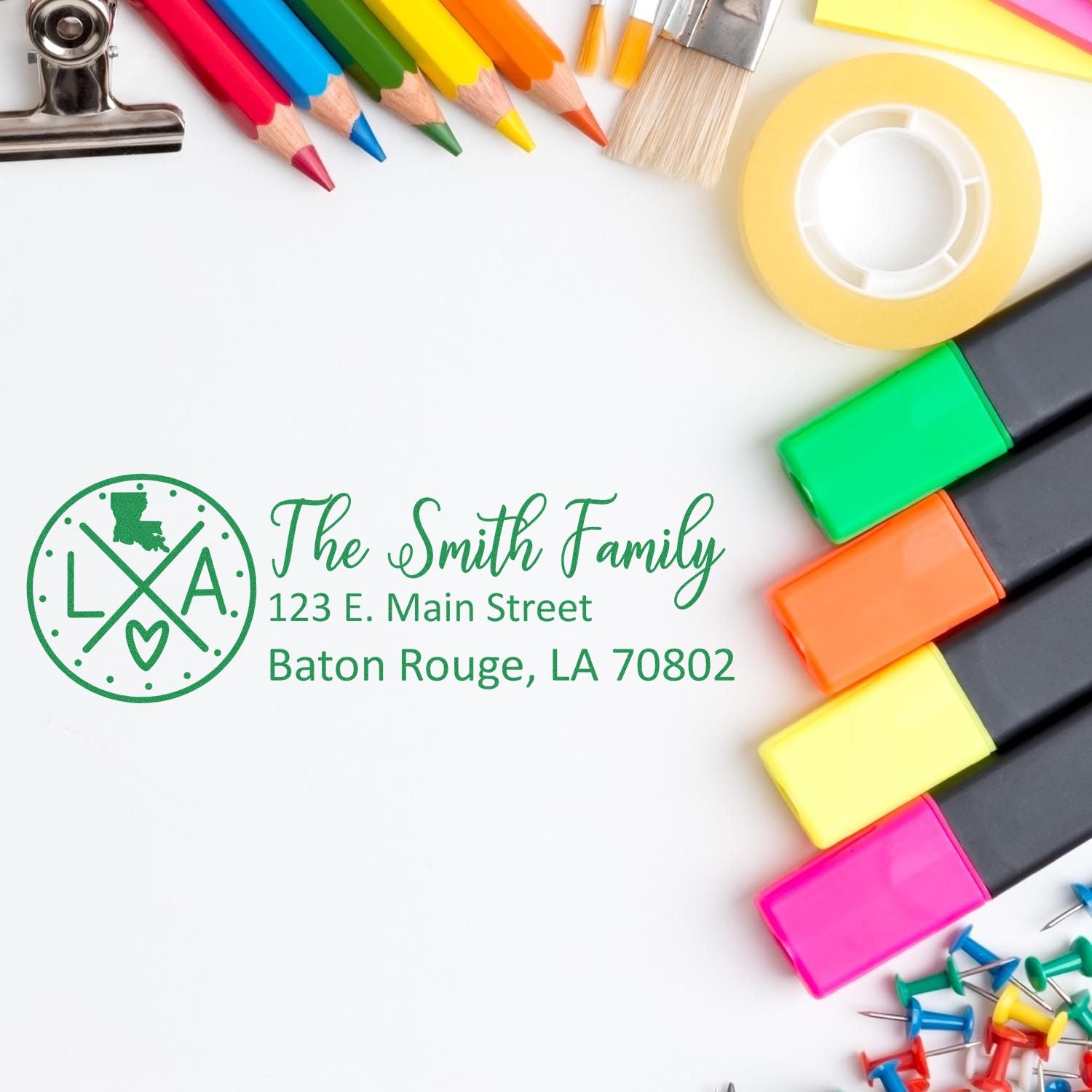 A Slim Louisiana Customized Pre-Inked Address Stamp imprint on white paper, surrounded by colorful stationery items like markers, pencils, and tape, showcasing its crisp, personalized design.