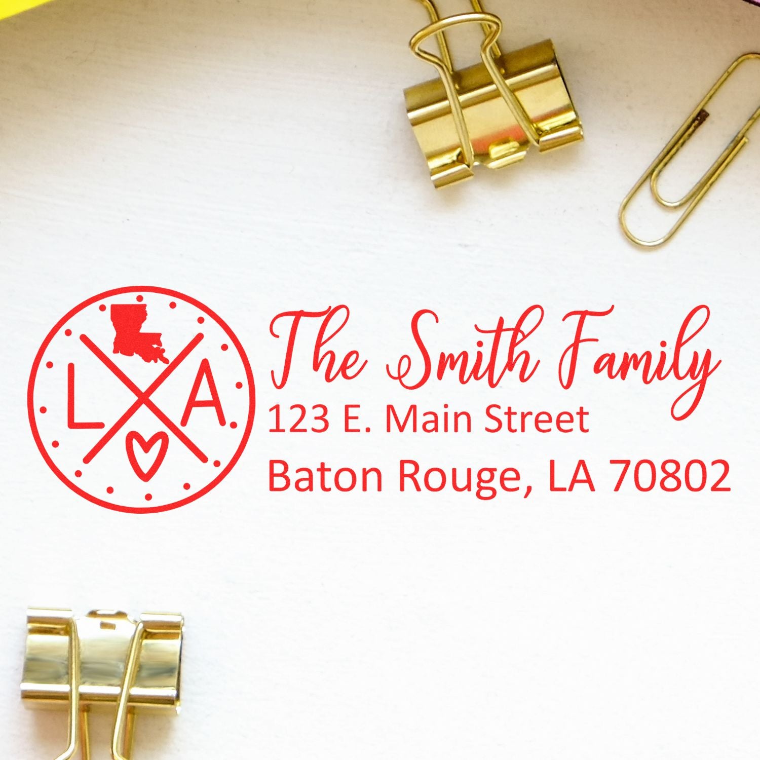 Slim Louisiana Customized Pre-Inked Address Stamp with red design featuring 'The Smith Family' and Baton Rouge address, shown on white paper with gold binder clips and paperclips.