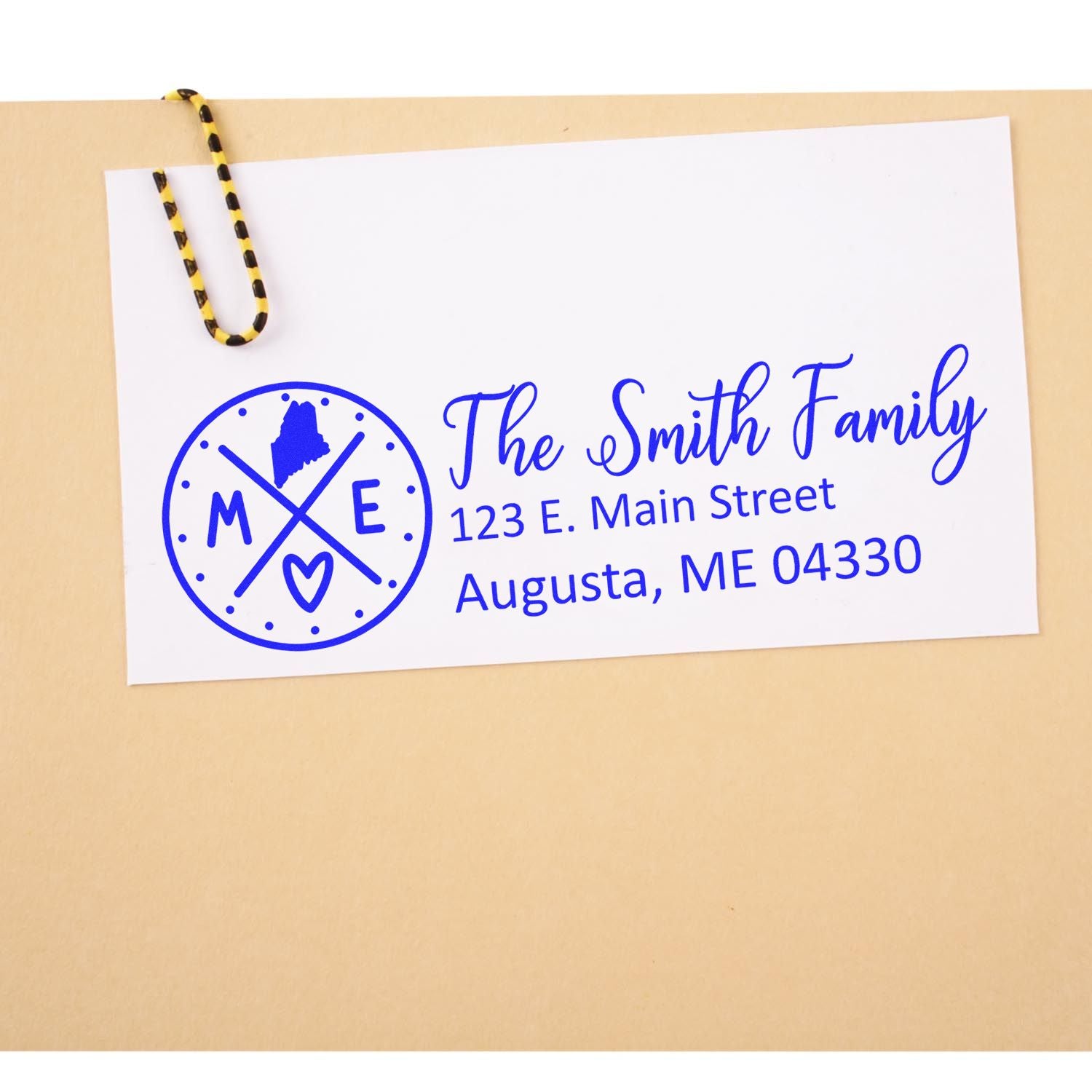 Envelope with blue ink from the Self-Inking State Love of Maine Custom Address Stamp, featuring a Maine state outline and heart, personalized with The Smith Family and an Augusta address.