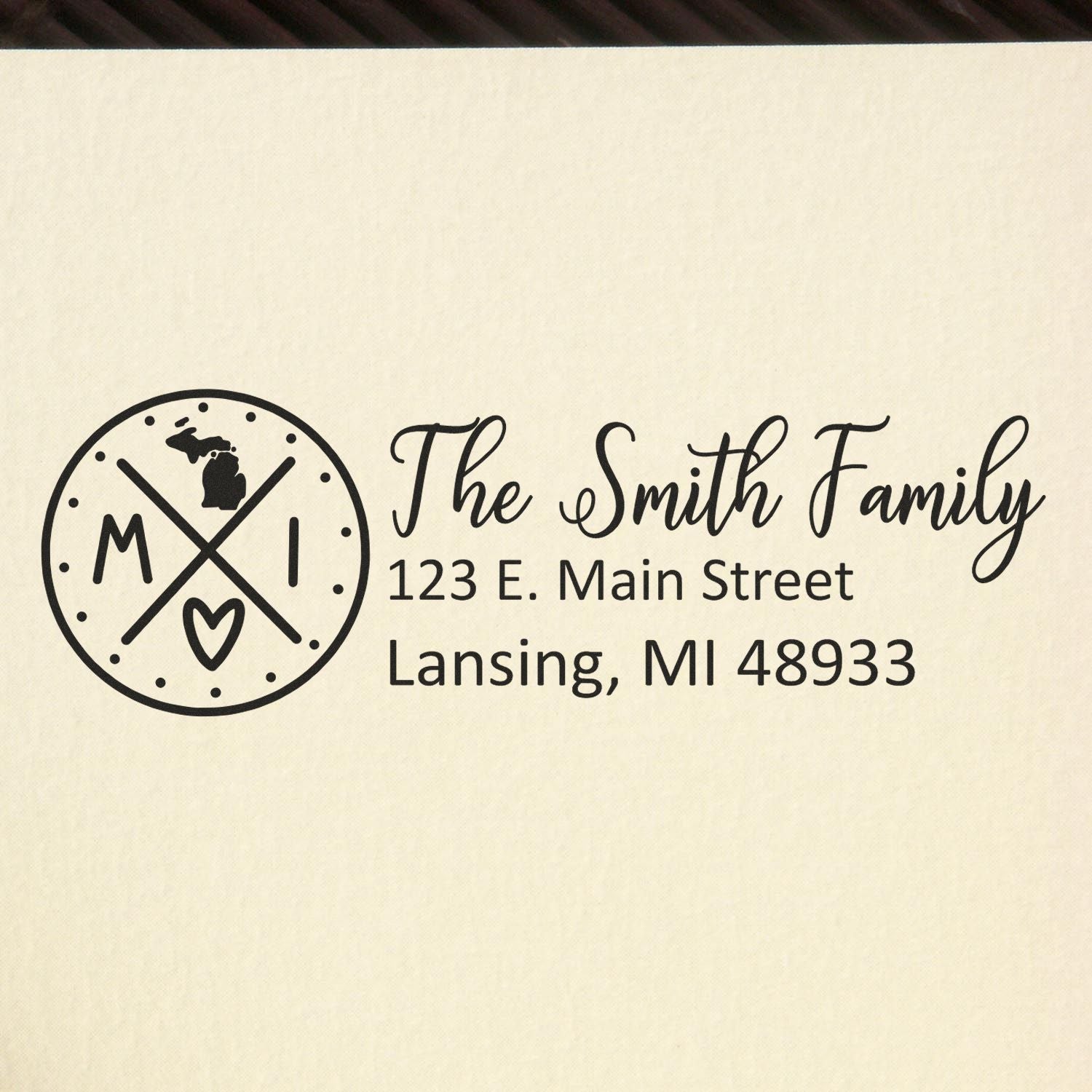 Michigan State Pride Customized Address Stamp featuring a circular design with MI and a heart, personalized with The Smith Family and an address in Lansing, MI, on a beige background.