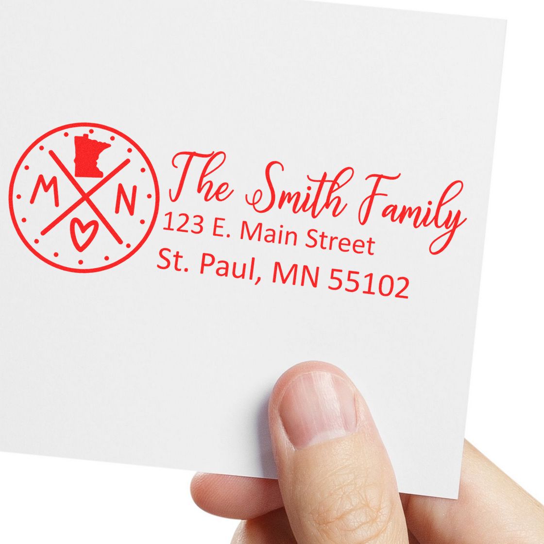 Hand holding an envelope with a red Minnesota State Pride Customized Address Stamp featuring a circular design, state outline, and personalized address for The Smith Family in St. Paul, MN.