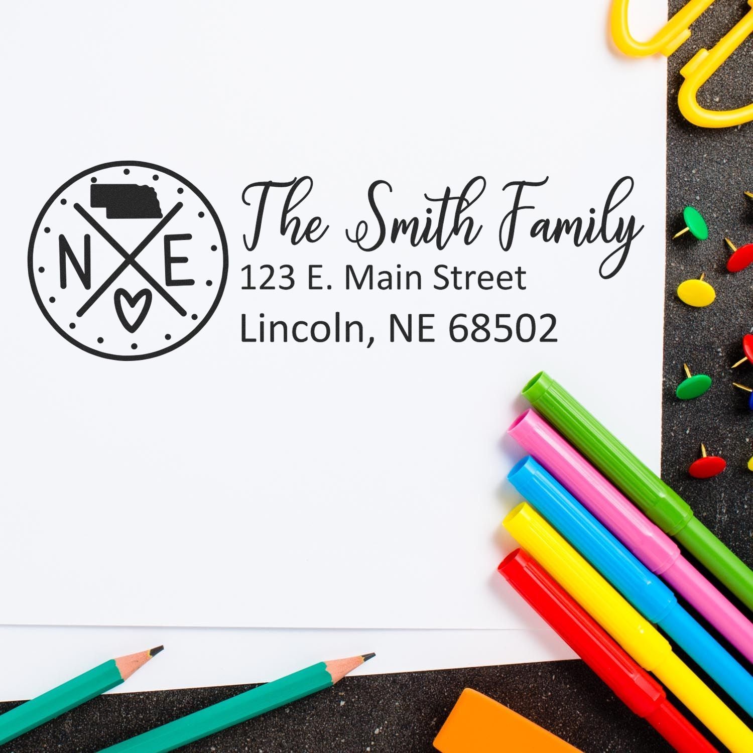 Nebraska State Pride Customized Address Stamp on white paper with colorful pens and paperclips. Features a Nebraska map and heart design, personalized with The Smith Family and address.