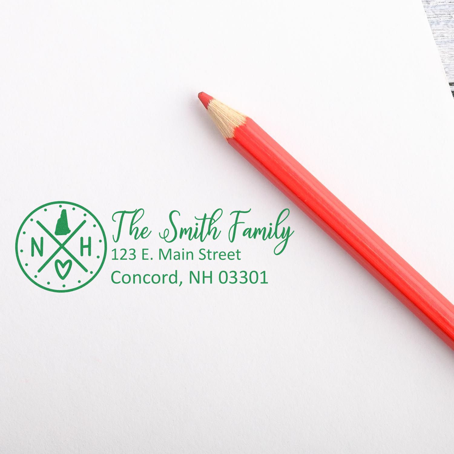 Self-Inking State Love of New Hampshire Custom Address Stamp on white paper with a red pencil. Features a circular NH design with a heart and address details in green ink.