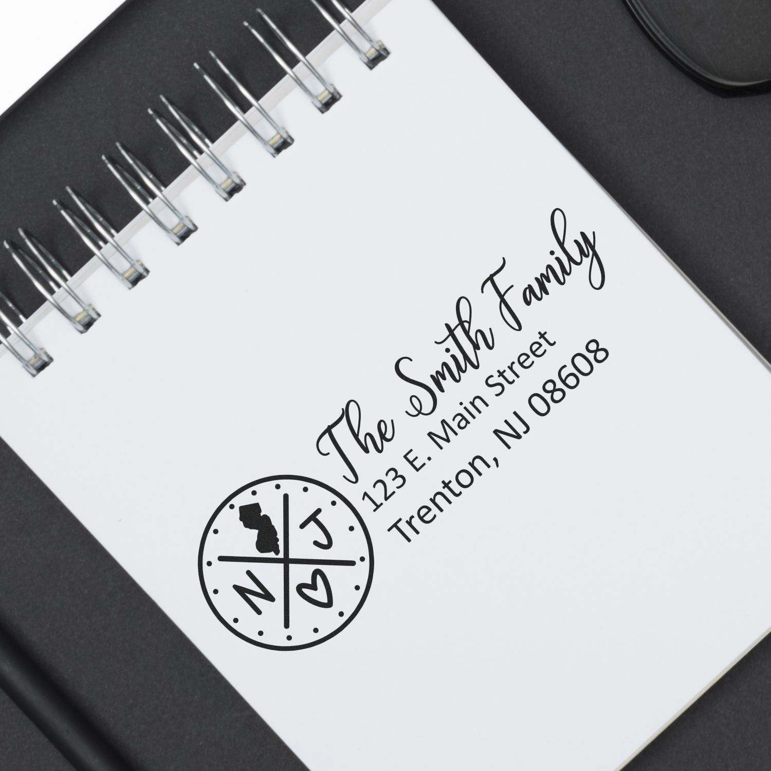 PSI Pre-Inked New Jersey State Pride Customized Address Stamp on a notebook, featuring a circular NJ design with a heart and state outline, personalized with a family name and address.