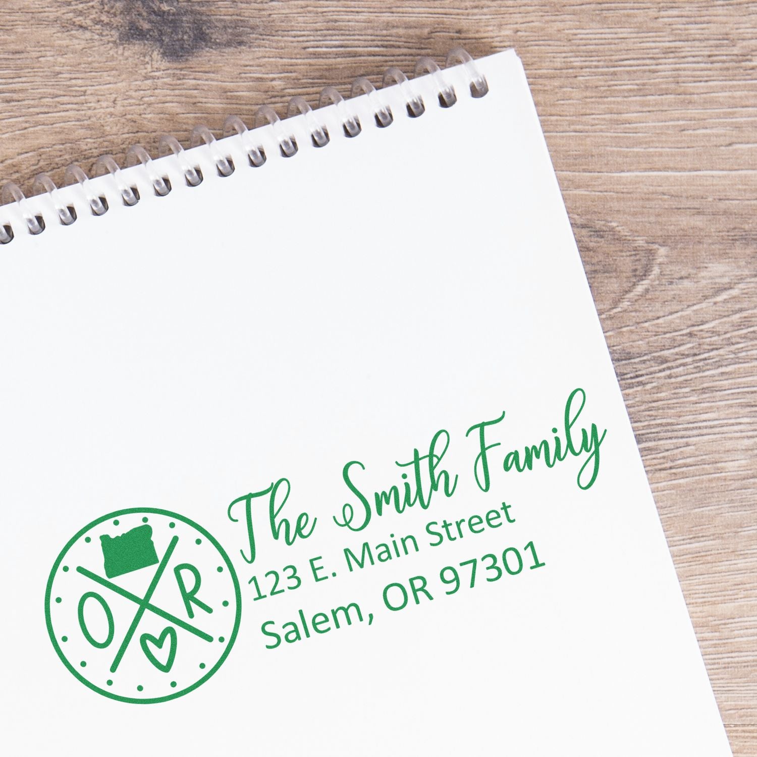 Self-Inking State Love of Oregon Custom Address Stamp on a notepad, featuring The Smith Family and an Oregon map design in green ink, with address 123 E. Main Street, Salem, OR 97301.