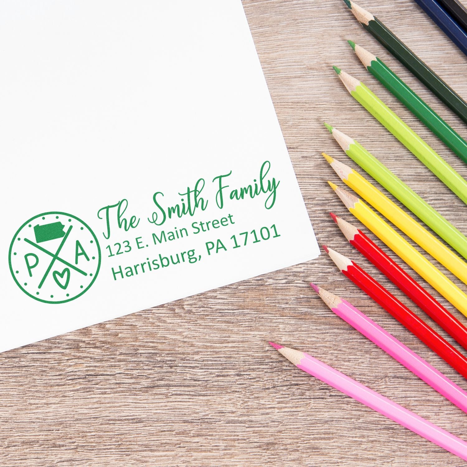 Pennsylvania State Pride Customized Address Stamp on white paper with colorful pencils. Features a circular PA design and personalized address for The Smith Family in green ink.