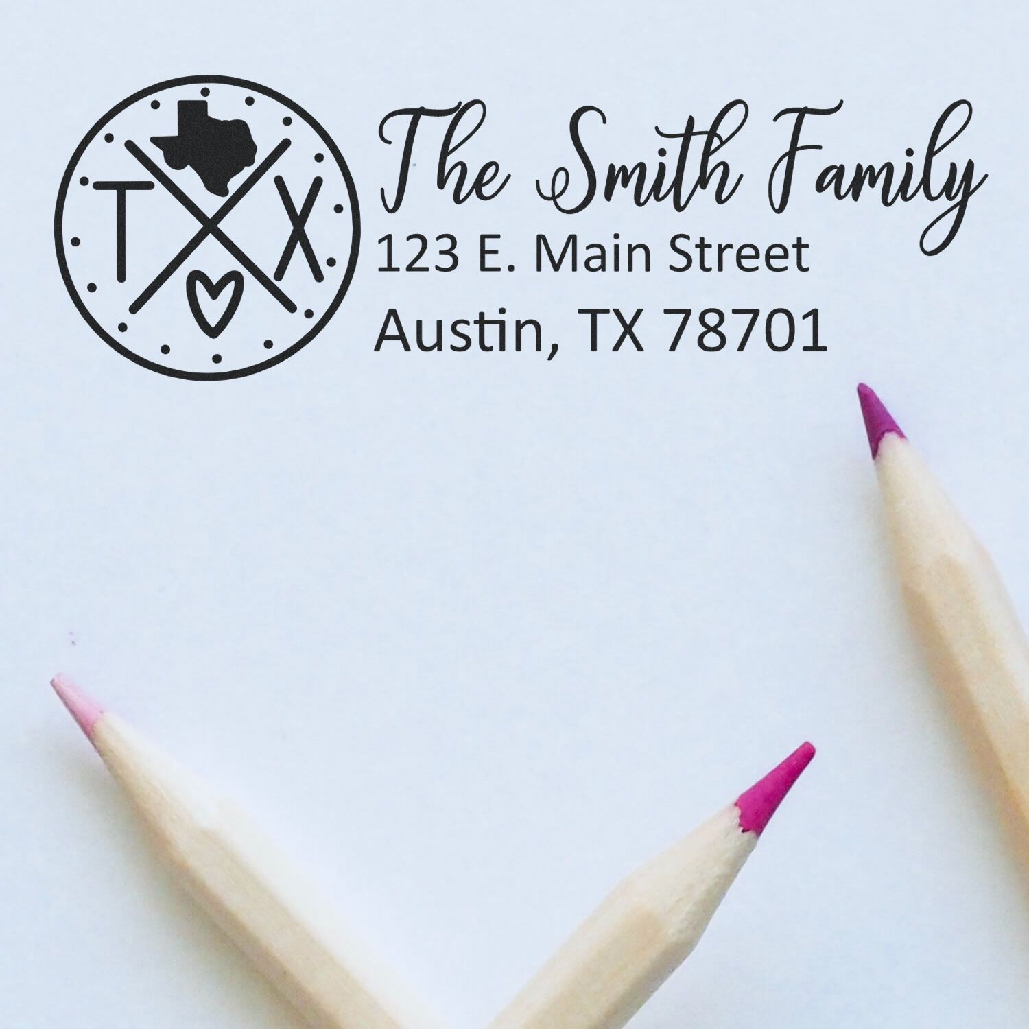 Texas State Pride Customized Address Stamp featuring a Texas outline, crossed lines, and a heart. Personalized with The Smith Family, 123 E. Main Street, Austin, TX 78701 on white paper with pencils.