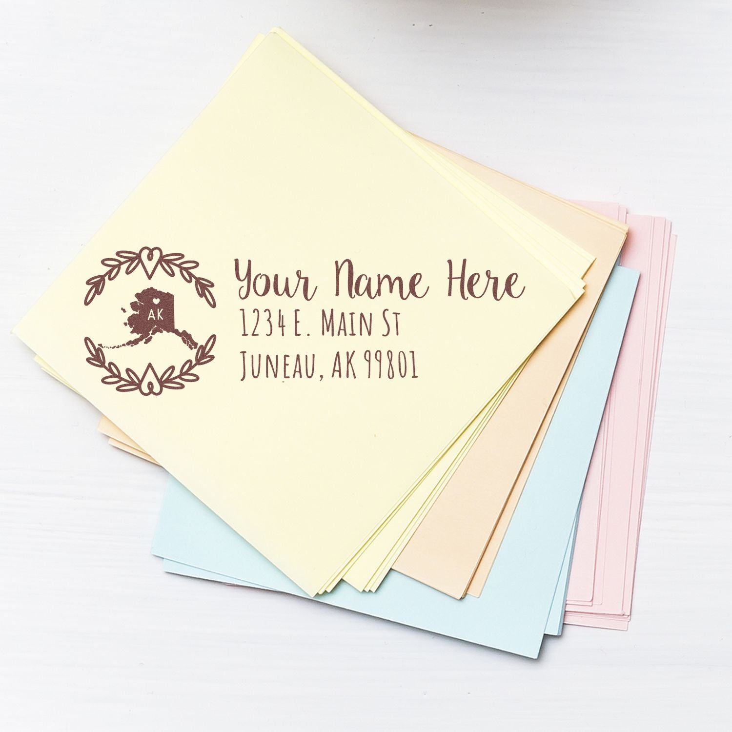 Alaska State Custom Return Address Stamp on pastel envelopes, featuring a map design with AK and space for personalized address details.