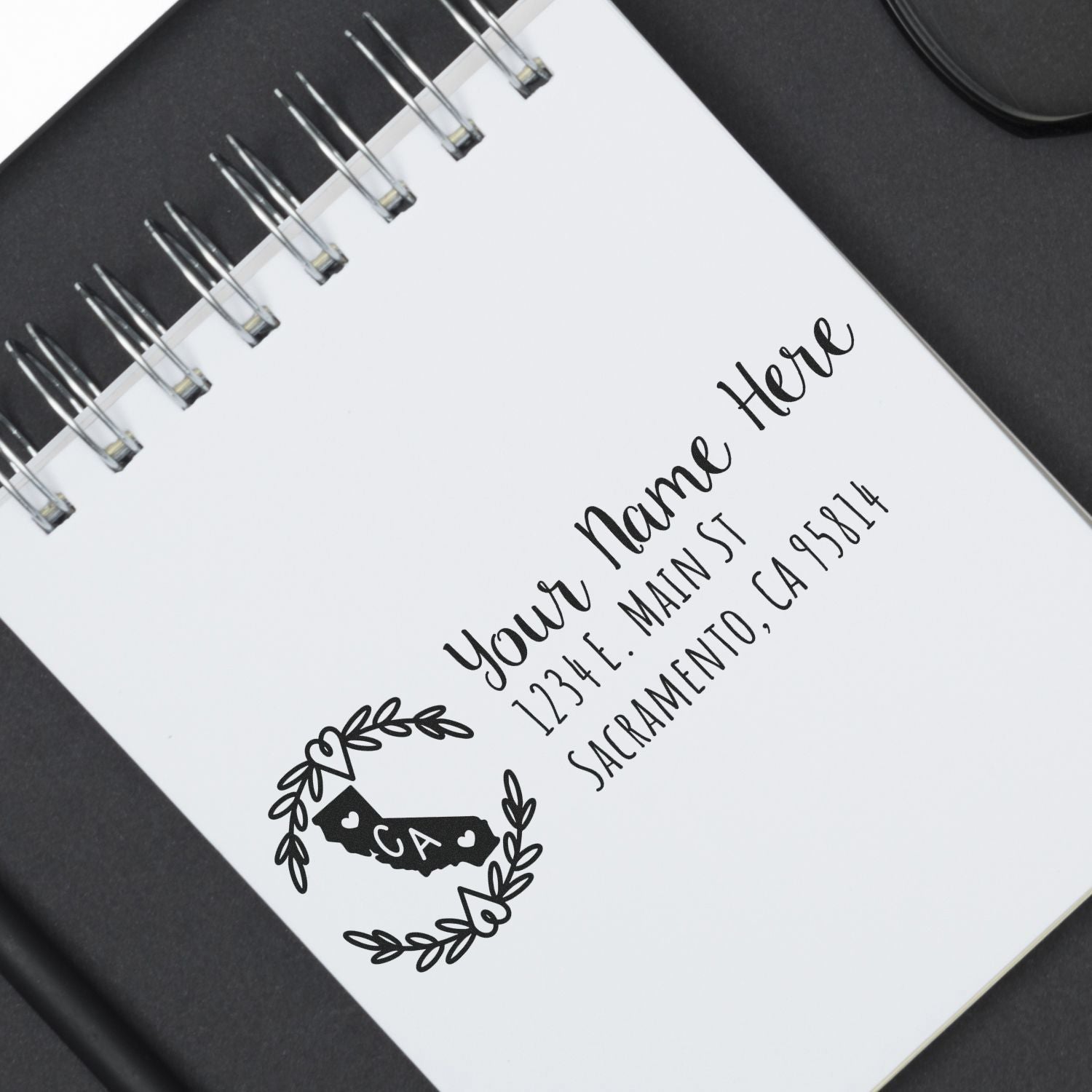 California State Custom Return Address Stamp on a notepad, featuring a stylized state outline with CA and space for personalized address details. Perfect for adding a personal touch to mail.