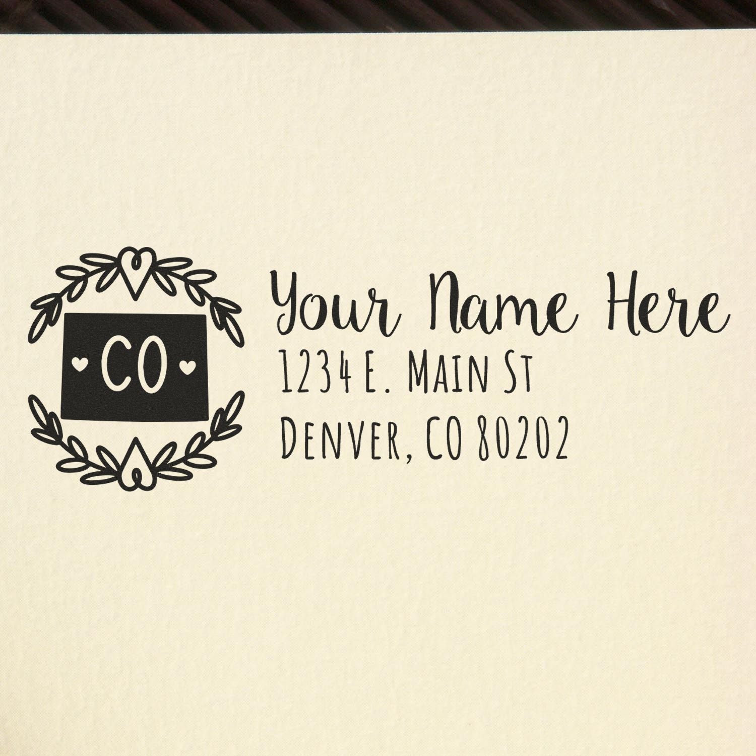 PSI Pre-Inked Colorado State Customized Address Stamp on beige paper, featuring a decorative CO emblem and placeholder text for name and address in Denver, CO.