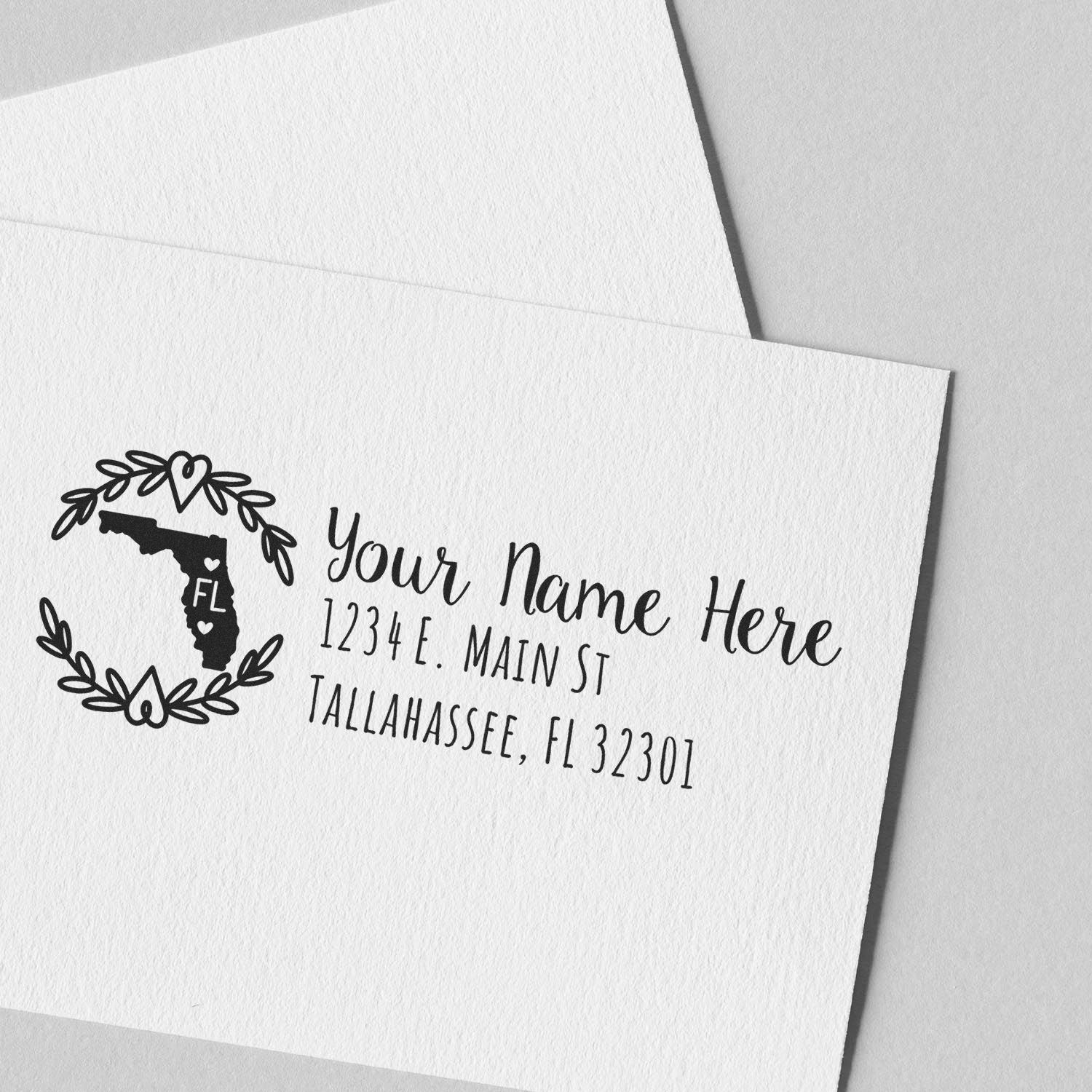 Florida State Custom Return Address Stamp on white paper, featuring a decorative outline of Florida with floral accents, personalized with name and address in elegant black font.