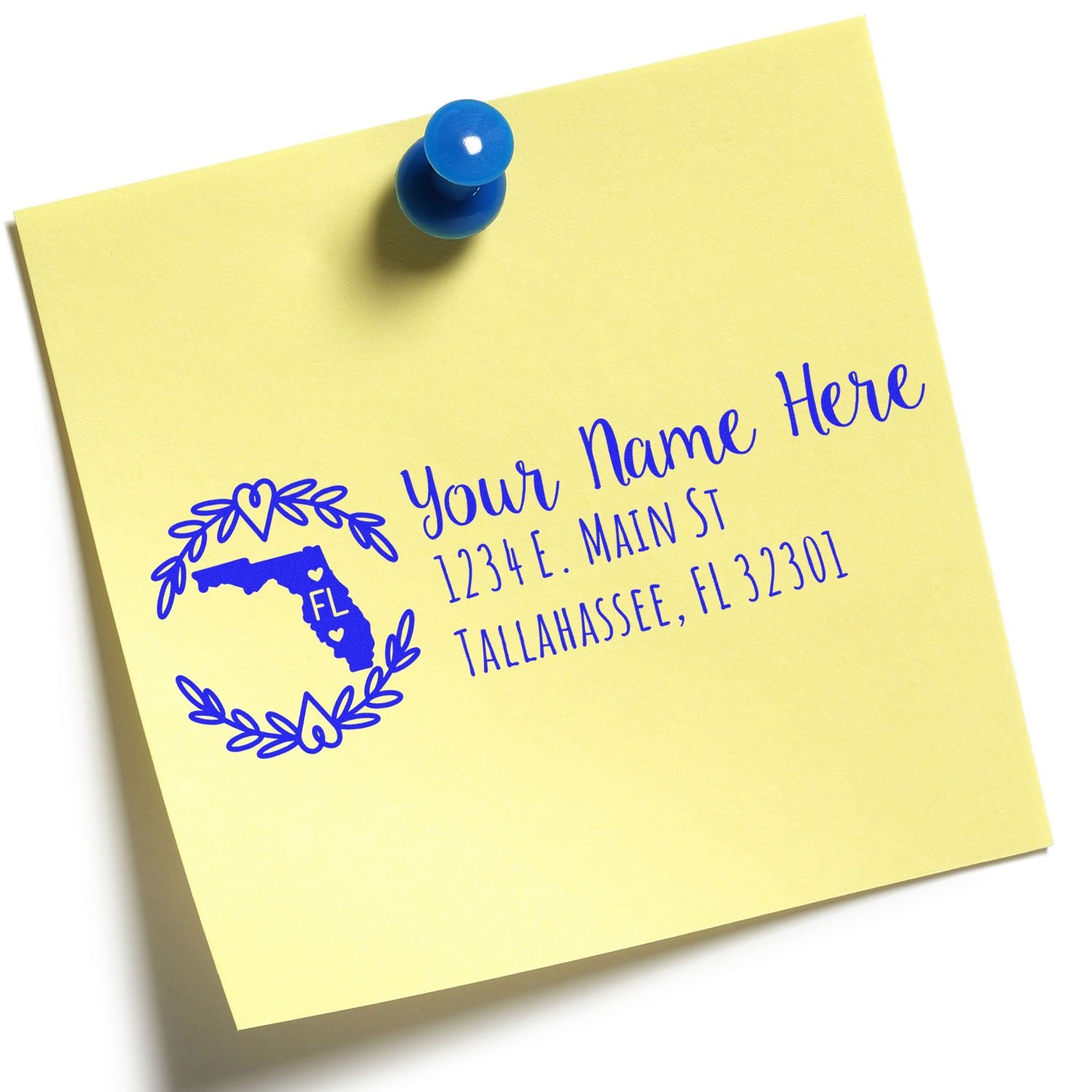 Yellow sticky note with a blue pushpin featuring the Florida State Custom Return Address Stamp design, including a heart and floral border, with placeholder text for name and address.