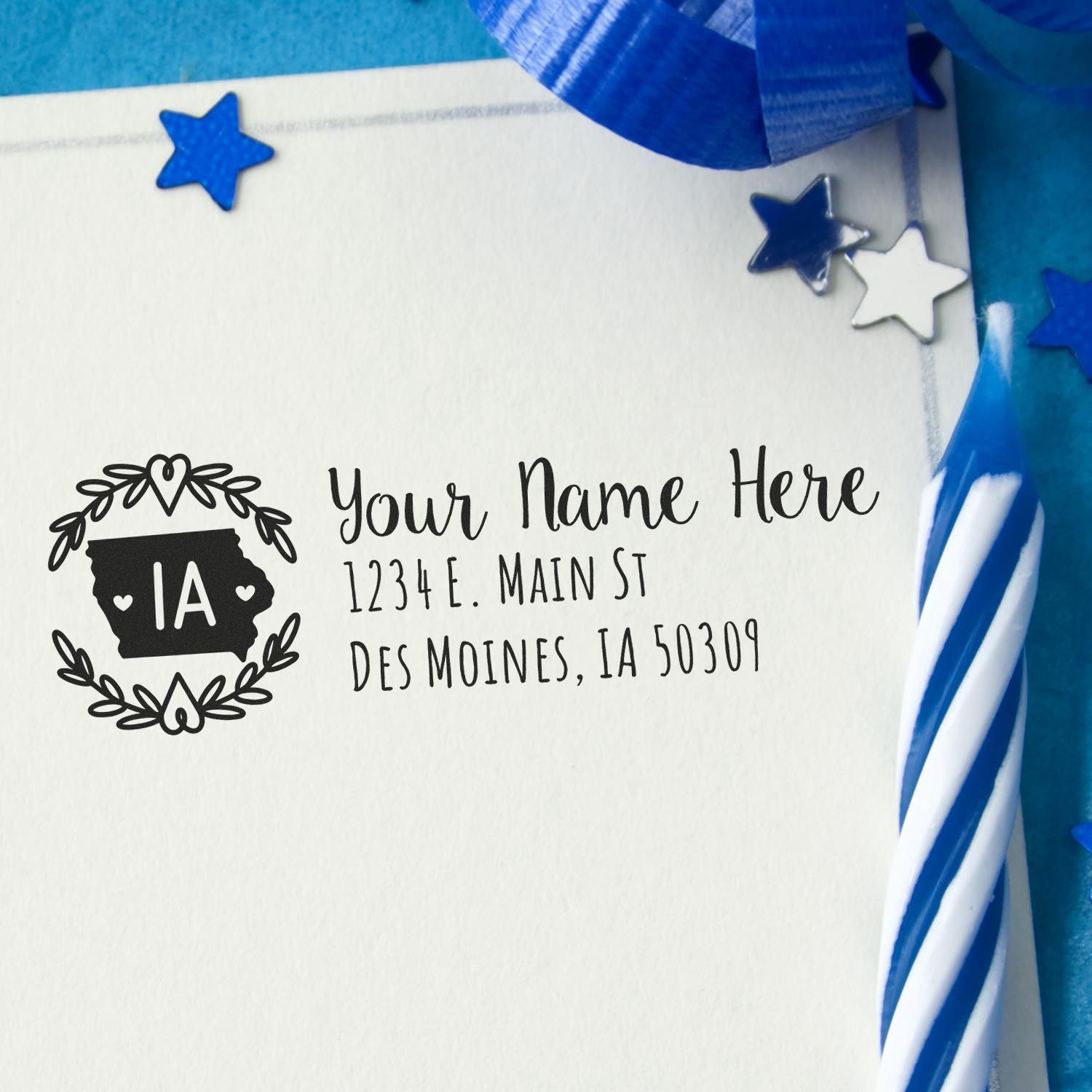 Iowa State Custom Return Address Stamp on an envelope with blue and white decorations, featuring a heart and state outline design, personalized with a sample address in Des Moines, IA.