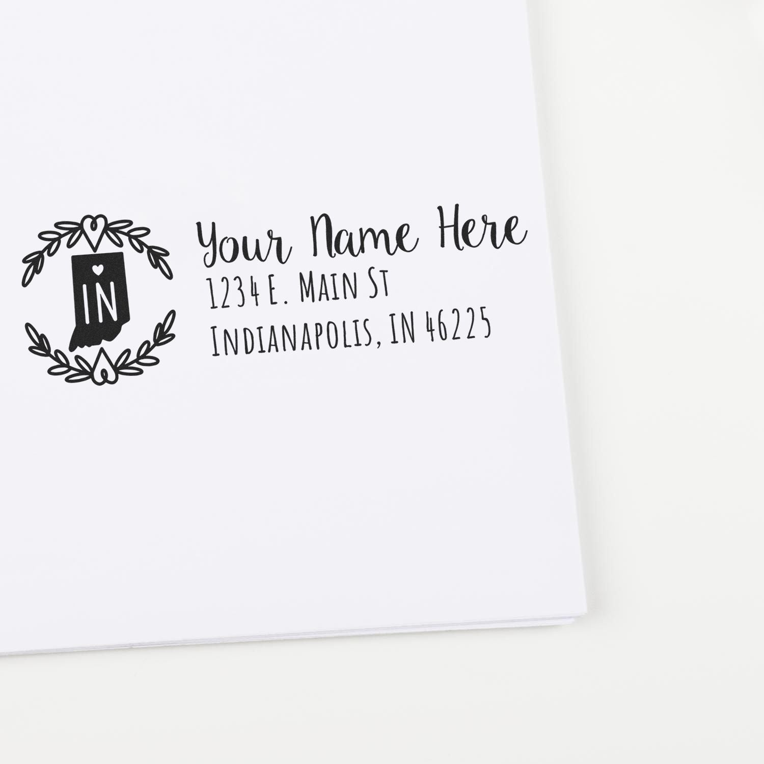 Self-Inking State Wreath of Indiana Address Stamp on white paper, featuring a decorative IN wreath design and customizable address text. Perfect for personalizing mail with an Indiana touch.