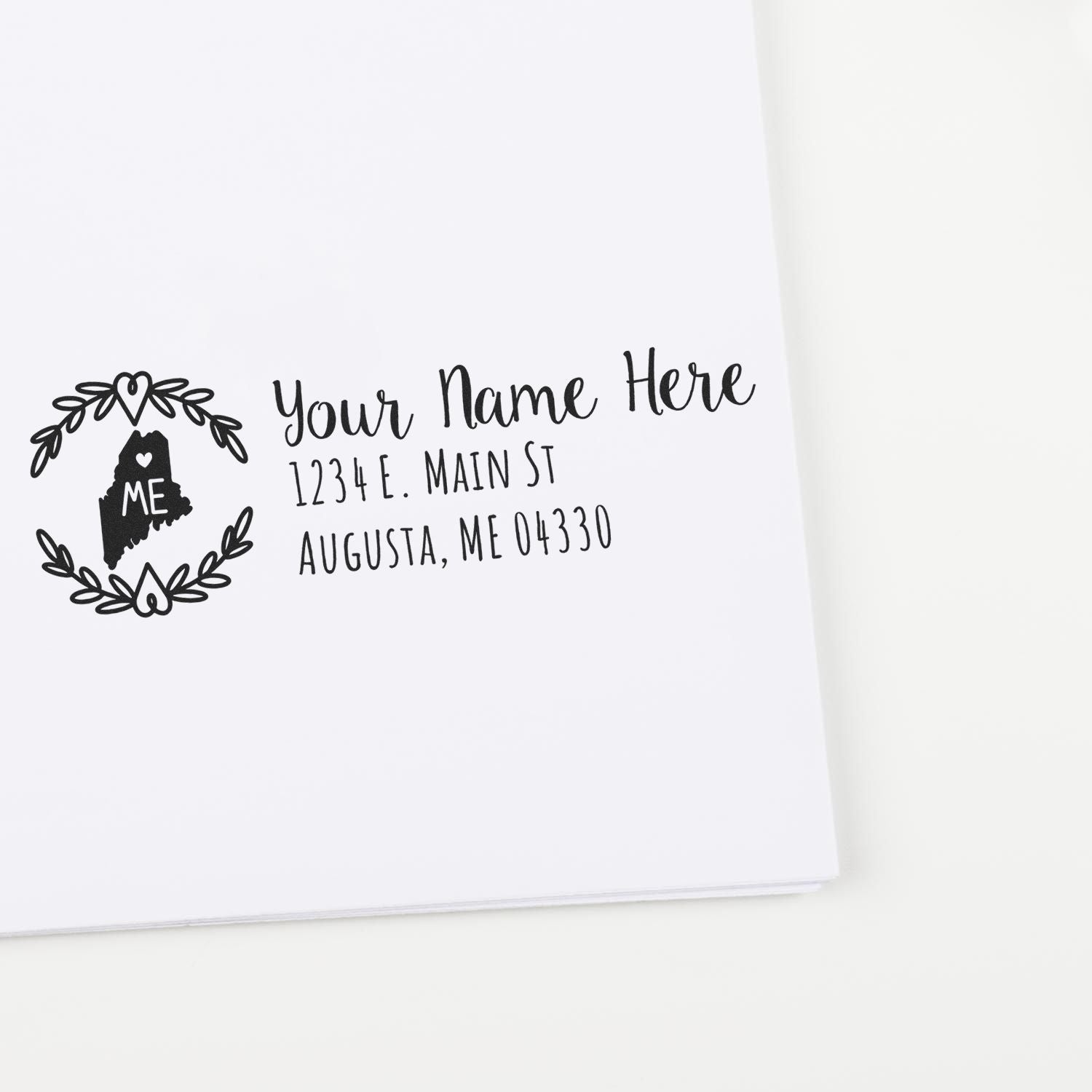 PSI Pre-Inked Maine State Customized Address Stamp on white paper, featuring a decorative Maine state outline with space for personalized name and address in elegant script.