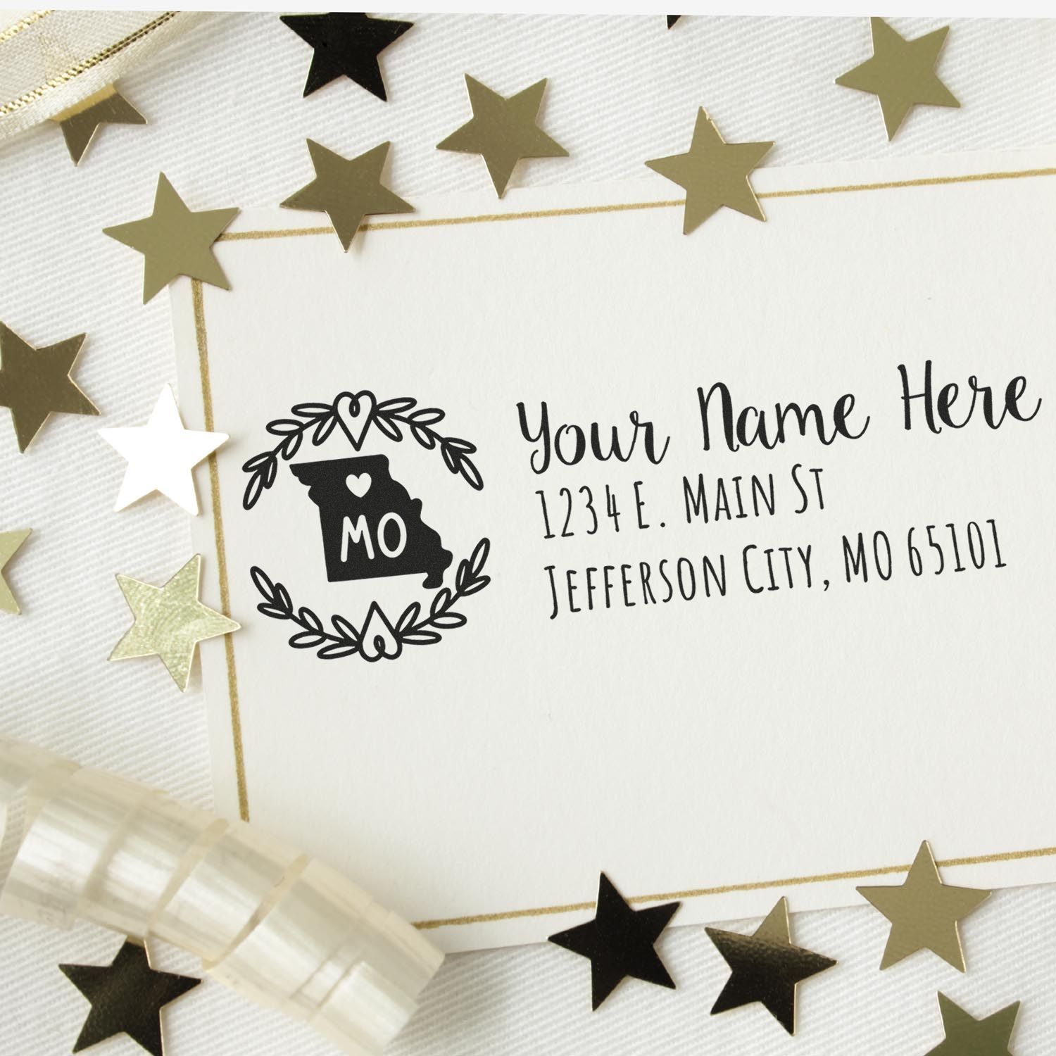 Missouri State Custom Return Address Stamp on an envelope with gold stars and ribbon, featuring a heart and state outline design, personalized with address details.