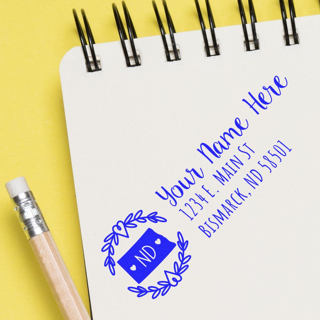 North Dakota State Custom Return Address Stamp on a notepad with a pencil. Features a blue design with ND and space for name and address. Perfect for personalizing mail.