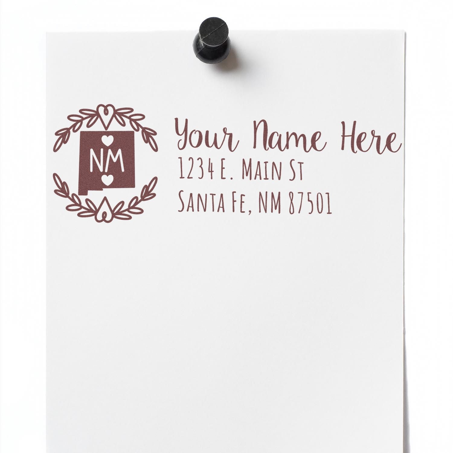 PSI Pre-Inked New Mexico State Customized Address Stamp on white paper with placeholder text Your Name Here and a decorative NM state design, pinned to a board.