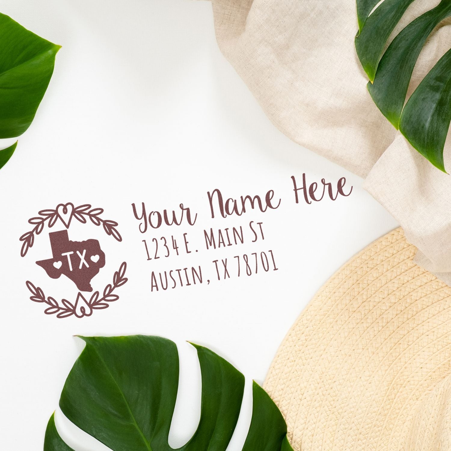 Slim Texas Personalized Pre-Inked Address Stamp on white paper with a Texas design, surrounded by green leaves and a beige hat, showcasing a custom address in elegant script.