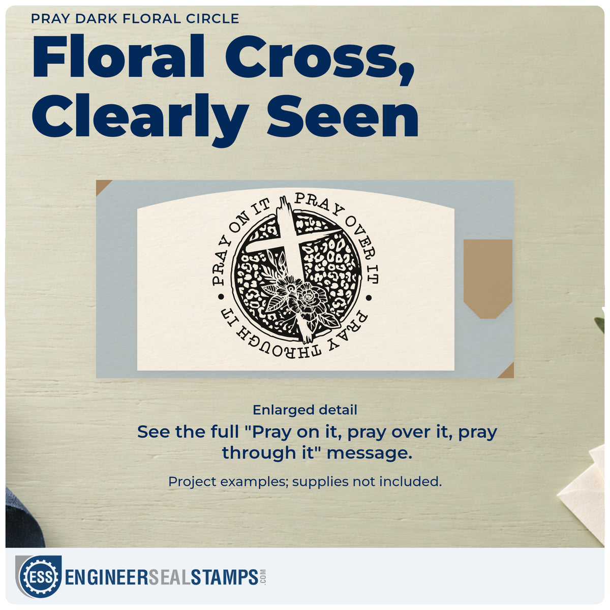 Enlarged detail of the Pray Solid Floral Circle PSI Pre-Inked Stamp imprint. A white cross and dark flowers fill a patterned circle bordered by "Pray on it, pray over it, pray through it."